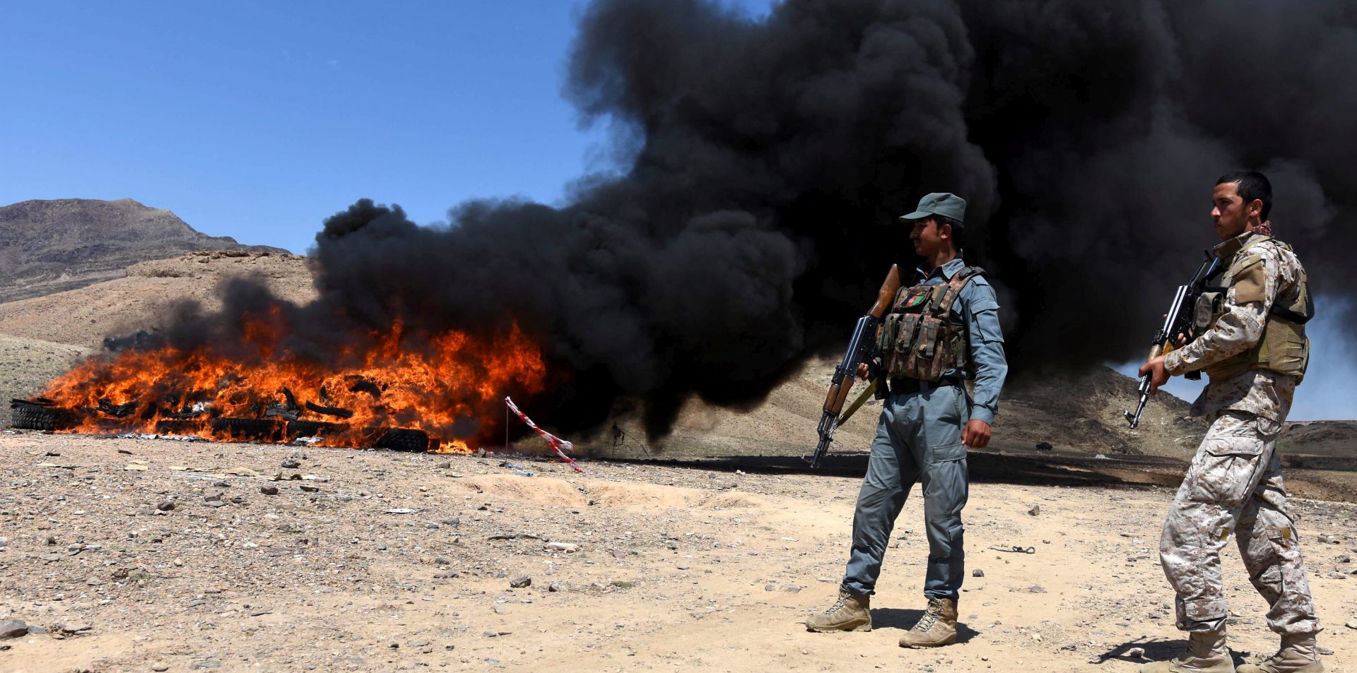 epa05255304 Afghan security officials guard the scene during the burning of confiscated illegal opium or raw heroine in Nangarhar province, Afghanistan, 12 April 2016. Afghan authorities burned opium which the security forces have confiscated during various recent operations across the country. Afghanistan is the world's largest producer of the drug.  EPA/GHULAMULLAH HABIBI