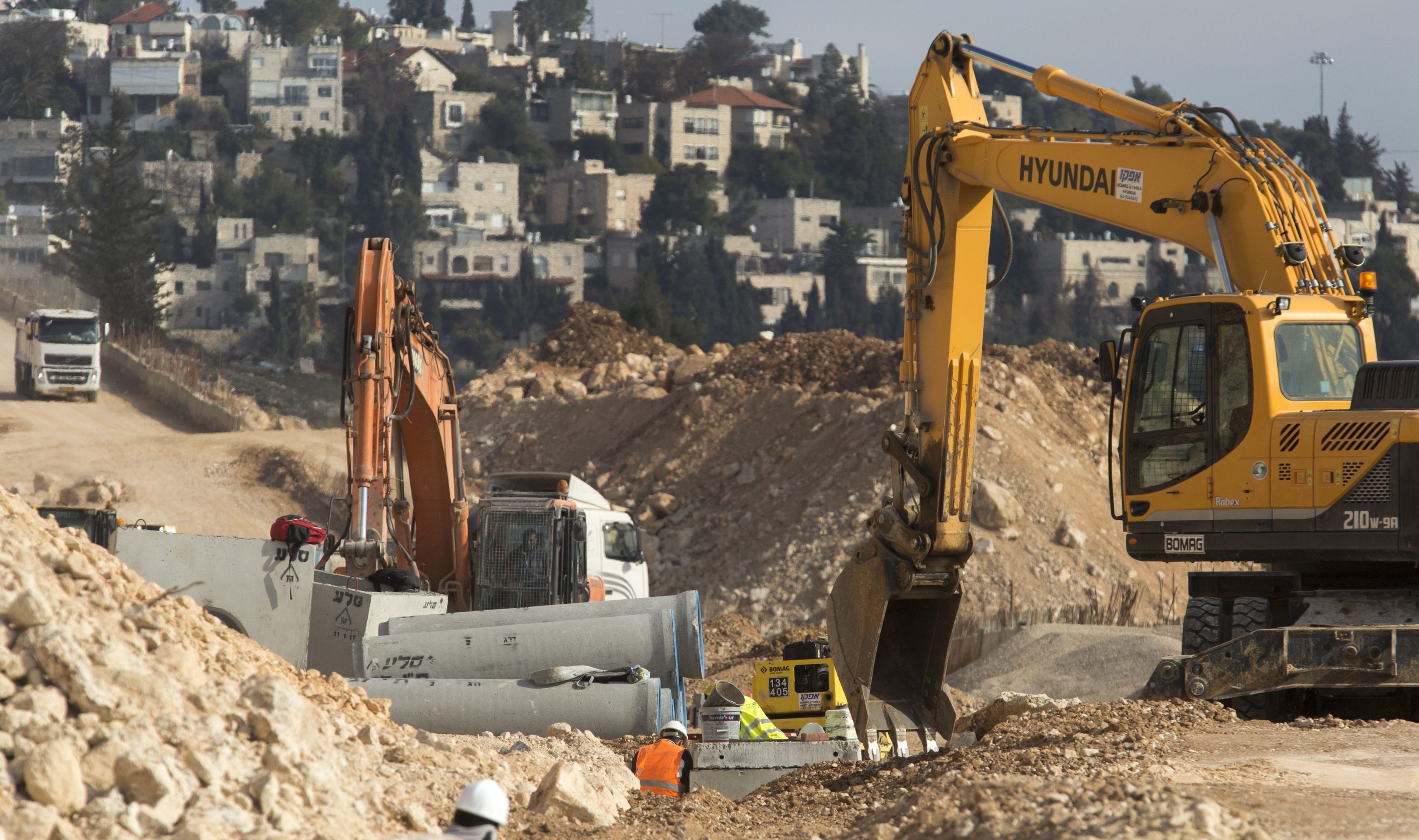 epa05741581 Earth moving equipment building infrastructure in Ramat Shlomo with the French Hill area of Jerusalem seen behind, 22 January 2017. The Jerusalem Municipality has approved the building of some 560 residential housing units some in this religious Jewish community on the northern reaches of Jerusalem and over the 1949 Armistice Line some 48 hours after US President Donald Trump's inauguration.  EPA/JIM HOLLANDER
