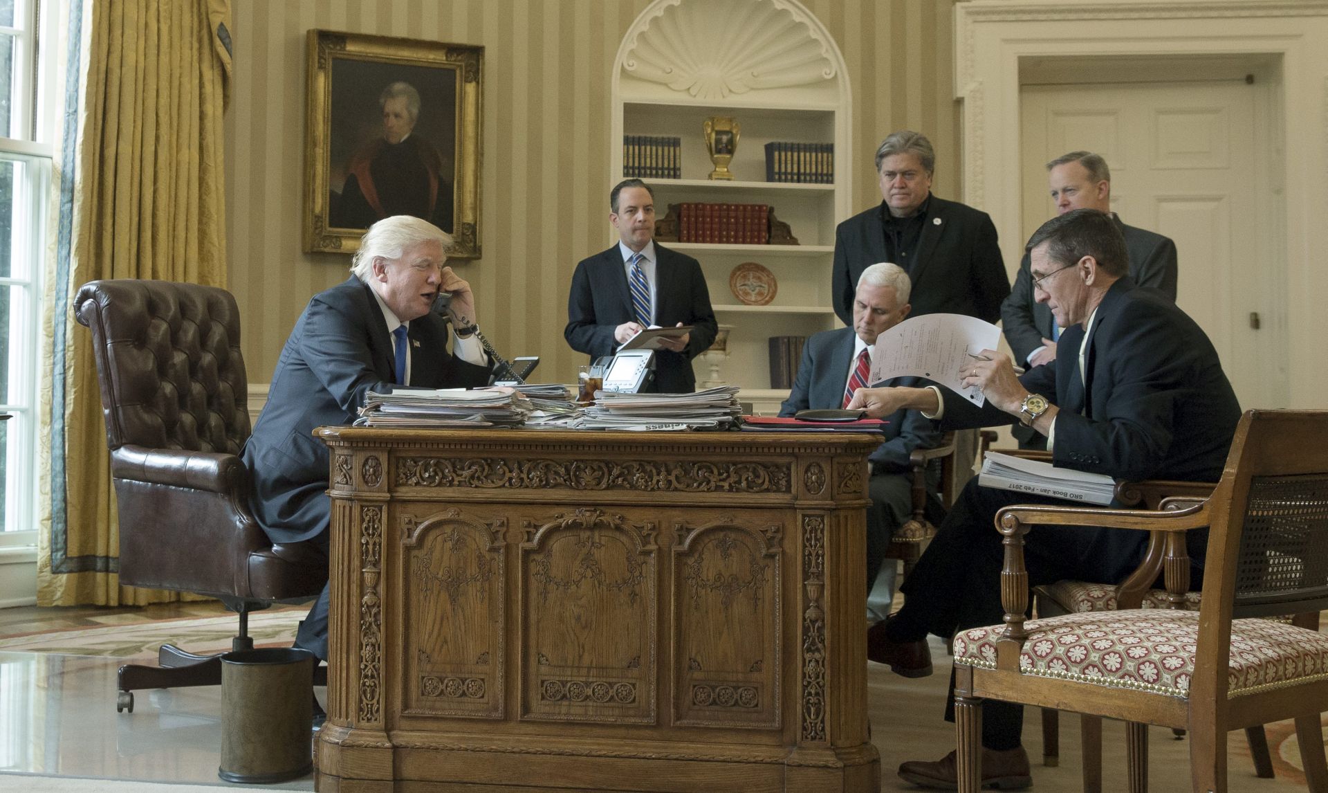 epa05757527 US President Donald J. Trump (L) speaks on the phone with President of Russia Vladimir Putin, in the Oval Office of the White House in Washington, DC, USA, 28 January 2017. President Trump has chosen the day to talk with different world leaders, significantly Russia's Vladimir Putin and Germany's Angela Merkel by telephone. Also in this picture; White House Chief of Staff Reince Priebus (2-L), US Vice President Mike Pence (3-L),  Chief Strategist and Senior Counselor Stephen Bannon (3-R), White House Press Secretary Sean Spicer (2-R) and National Security Advisor, retired Lieutenant General Michael Flynn.  EPA/MICHAEL REYNOLDS