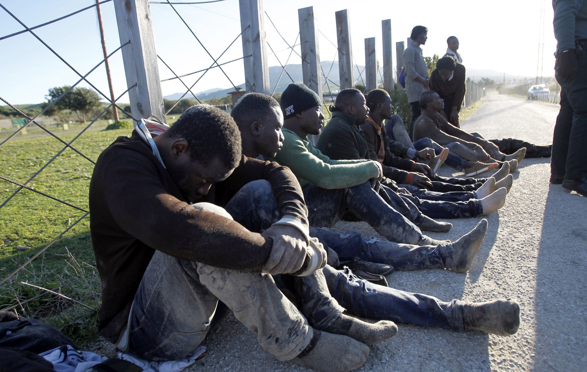 epa05761383 Some eleven Sub-Saharan immigrants wait to receive medical care after arriving on board a small boat to the beach of Bolonia in Tarifa, province of Cadiz, southwestern Spain, 30 January 2017.  EPA/A.CARRASCO RAGEL