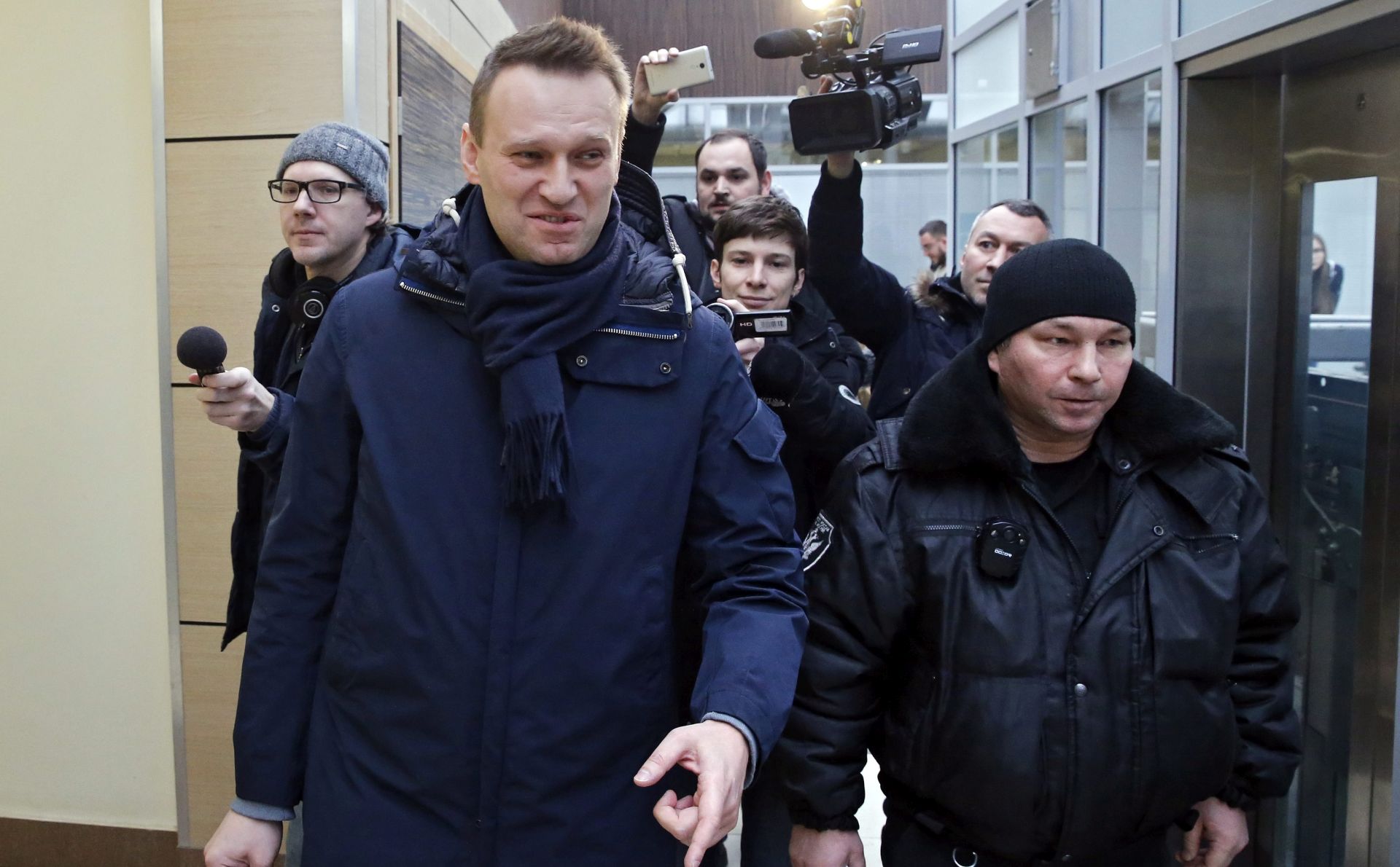 epa05762826 Russian opposition leader Alexei Navalny (front, L) escorted by a Moscow bailiff goes from the Anti-Corruption Foundation headed by Navalny in Moscow, Russia, 31 January 2017. A judge of Kirov Leninsky District court has issued a resolution on a compulsory delivery of Alexei Navalny accused of embezzlement, to the court hearing scheduled on 01 February 2017, as Navalny did not  appear at the two previous hearings. Earlier, in December 2016 , Alexei Navalny announced that he would run in 2018 Russian presidential elections.  EPA/YURI KOCHETKOV