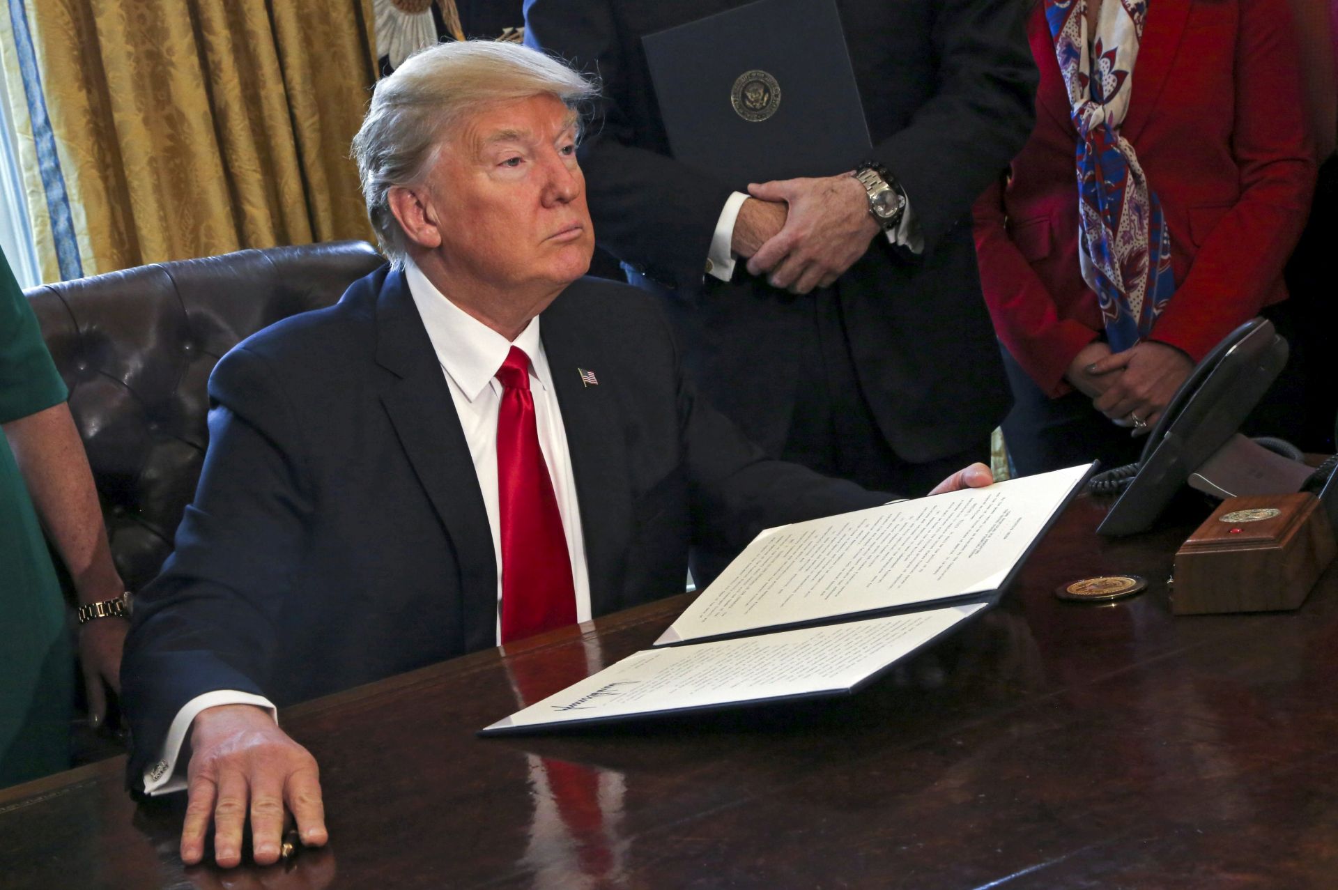 epa05769557 US President Donald J. Trump poses after signing an executive order in the Oval Office of the White House, in Washington, DC, USA, 03 February 2017. Trump signed several executive orders including an order to review the Dodd-Frank Wall Street to roll back financial regulations of the Obama era.  EPA/Aude Guerrucci / POOL
