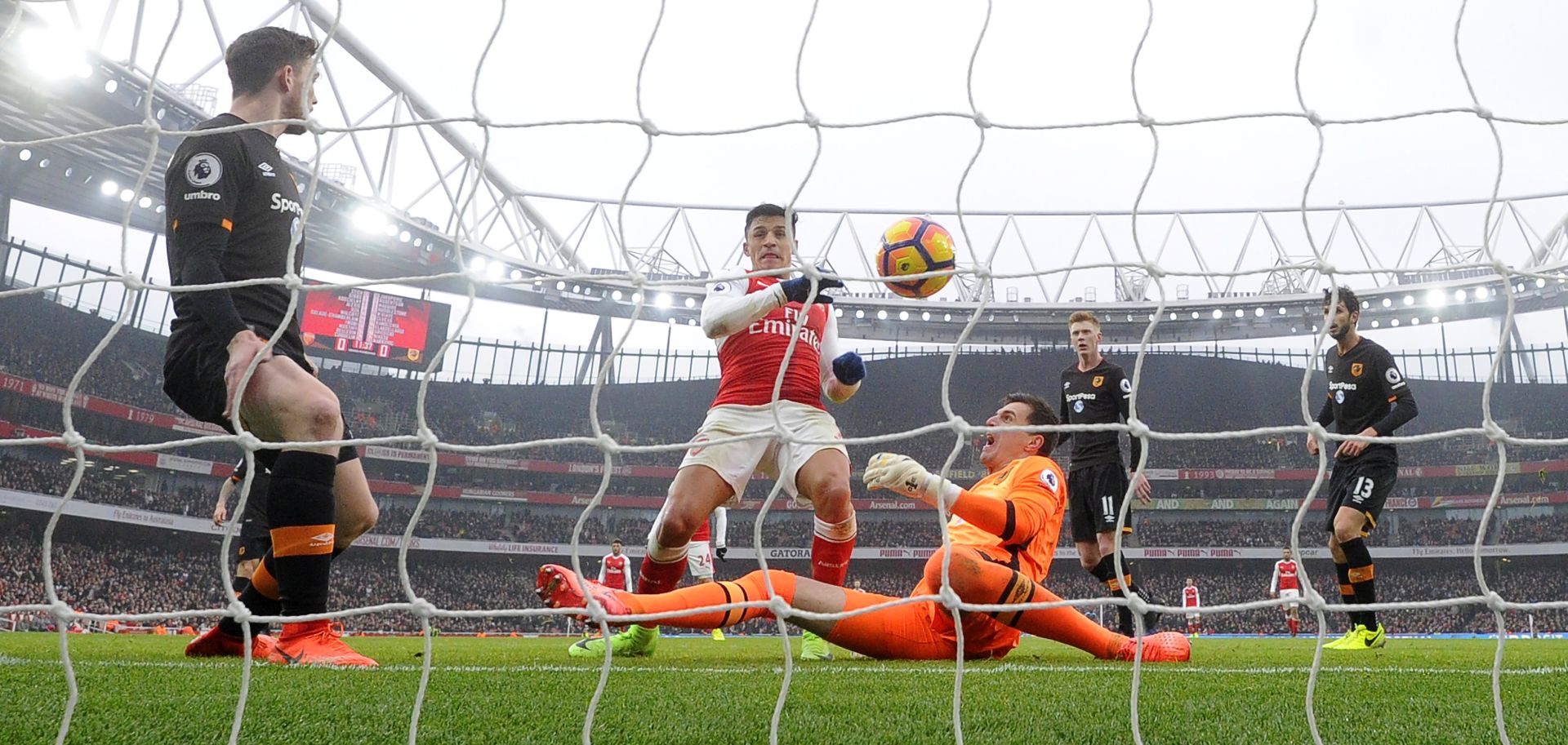 epa05784934 Arsenal's Alexis Sanchez (C) scores the 1-0 lead against Hull's goalkeeper Eldin Jakupovic (bottom) during the English Premier League soccer match between Arsenal FC and Hull City in London, Britain, 11 February 2017.  EPA/FACUNDO ARRIZABALAGA EDITORIAL USE ONLY. No use with unauthorized audio, video, data, fixture lists, club/league logos or 'live' services. Online in-match use limited to 75 images, no video emulation. No use in betting, games or single club/league/player publications.