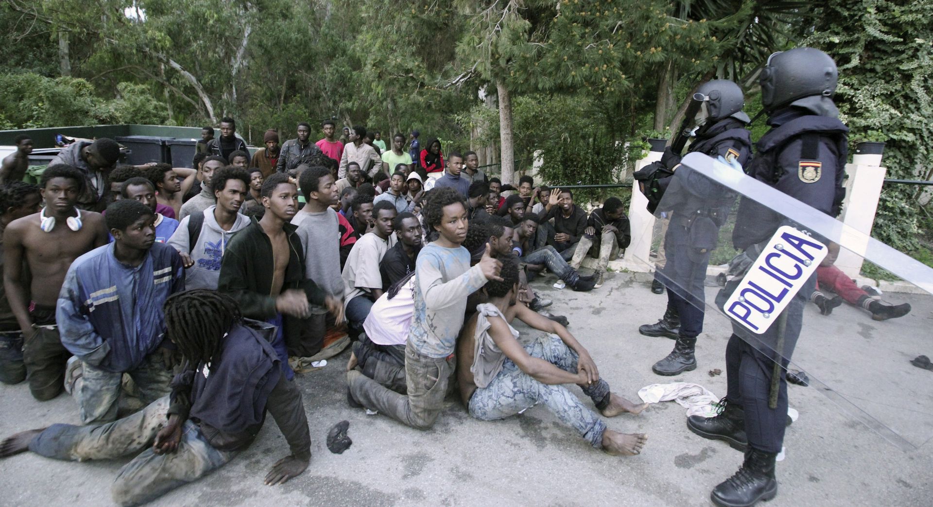 epa05798715 Spanish policemen observe dozens of migrants who managed to cross and jump the fences at the Tarajal border in Ceuta, Spain, 17 February 2017. Some 500 Sub-Saharan migrants entered the Spanish enclave of Ceuta in Africa enmass. Approximately 350 of the 500 migrants who managed to cross and jump into Spanish territory were sent to the local temporary immigrant holding center (CETI), which has passed maximum capacity. The last mass border crossing attempt occured on 09 December, when some 438 Sub-Saharan immigrants managed to enter the country.  EPA/REDUAN