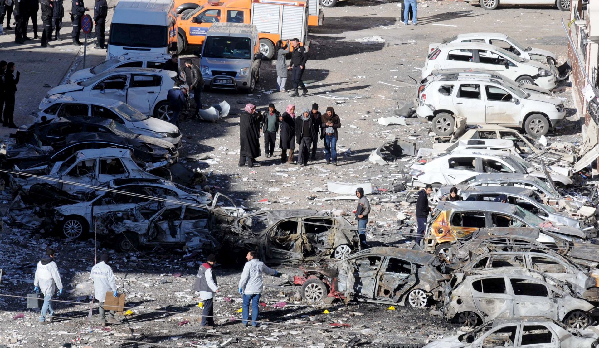 epa05801159 Crime scene investigators work next to damaged cars at the scene of an explosion that occurred a day earlier, in Viransehir, Sanliurfa, Turkey, 18 February 2017. Reports state at least two people were killed and 15 others wounded on 17 February in the explosion targeting building housing judges in Sanliurfa province.  EPA/HASAN KIRMIZITAS TURKEY OUT