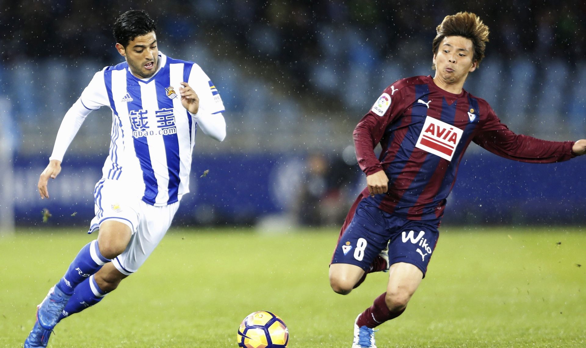 epa05821291 Real Sociedad's Carlos Vela (L) fights for the ball with Takashi Inui (R) of SD Eibar during the Spanish Primera Division soccer match between Real Sociedad and SD Eibar at Anoeta stadium in San Sebastian, Basque Country, Spain, 28 February 2017.  EPA/JUAN HERERRO