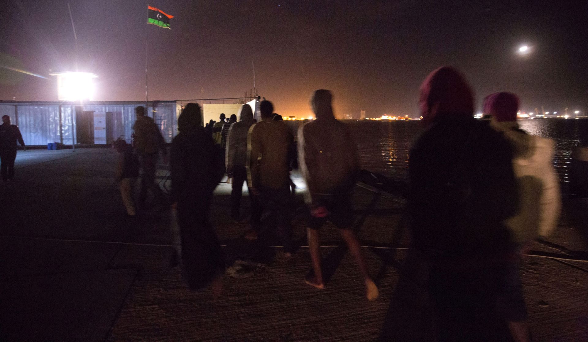 epa05773175 Immigrants walk after they arrived at Tripoli port, Libya, 04 February 2017 (Issued 05 February 2017). An inflatable boat was found off the coast of Tripoli by the Libyan Coast Guard carrying some 120 migrants, including four children, 10 women, and a 20 days old newborn. They were supposedly going from Sabratha to Italy. According to immigrants they were on the boat for about 20 hours before they were founded by the Libyan Coast Guard.  EPA/STR