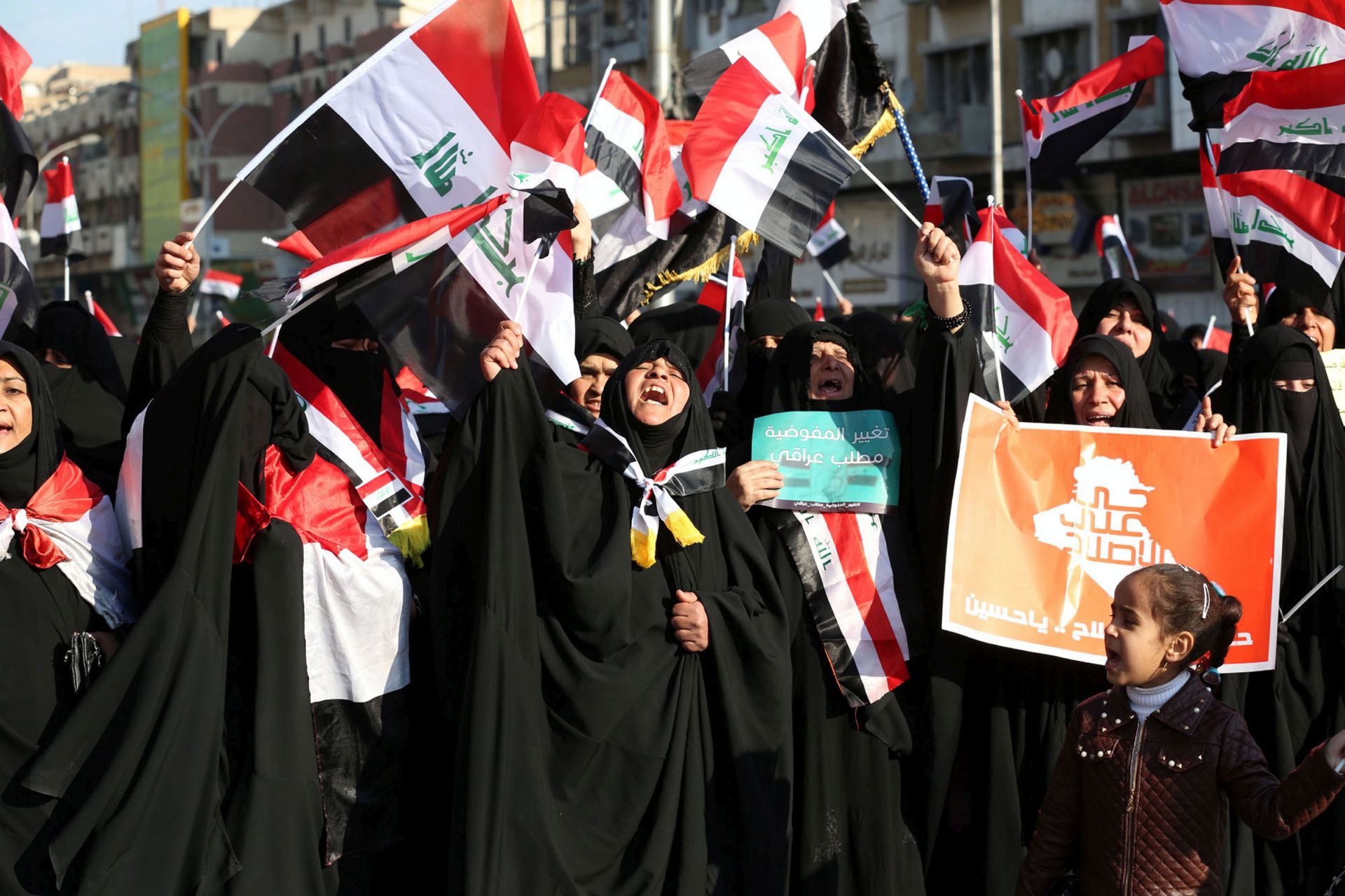 epa05784905 Supporters of Iraqi Shiite cleric Muqtada al-Sadr wave national flags and chant slogans during a demonstration at al-Tahrer square, central Baghdad, Iraq, 11 February 2017. Reports state that thousands of al-Sadr supporters gathered in a new protest calling for a change in the countrys electoral commission, governmental reforms and elimination of corruption.  EPA/ALI ABBAS