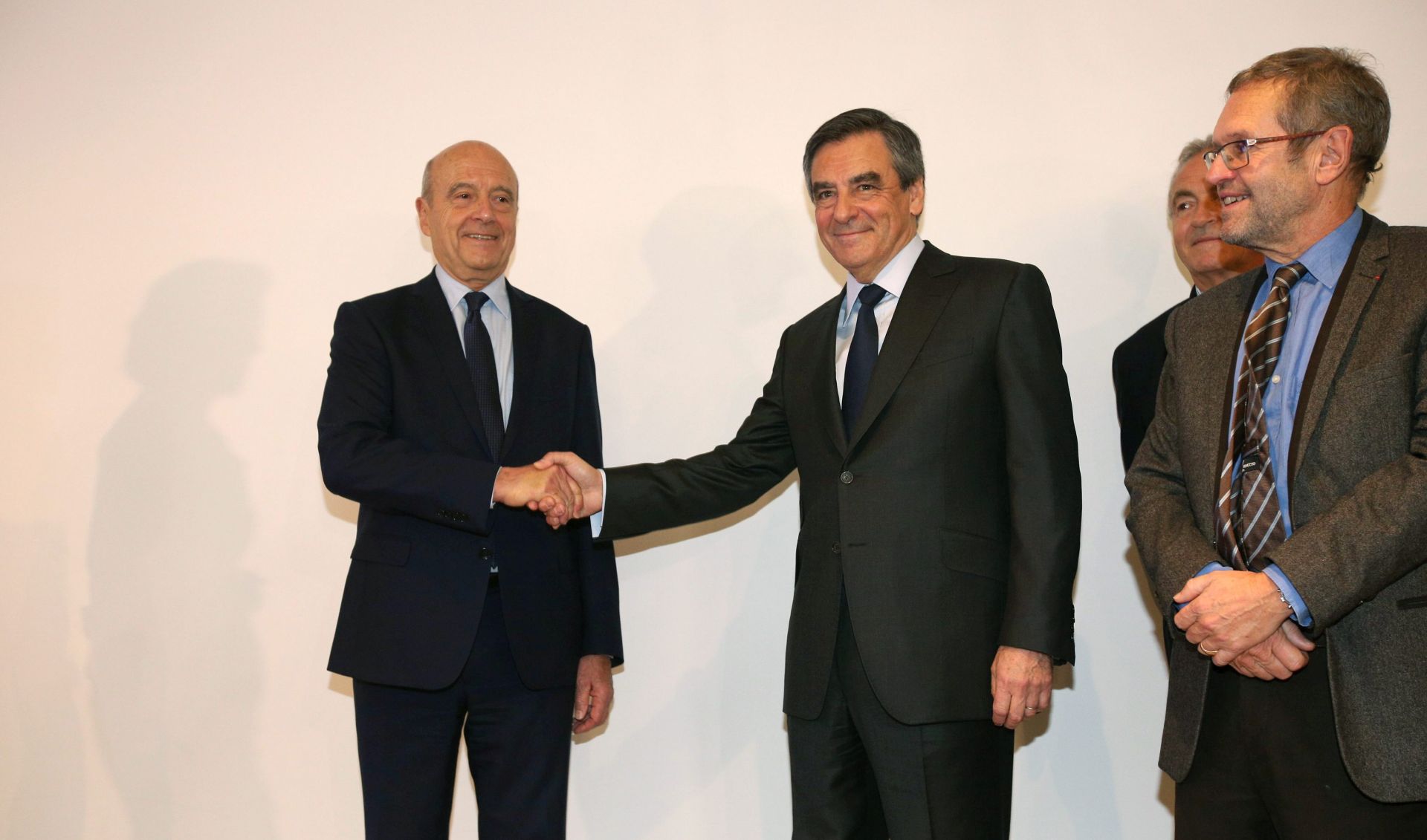 epa05650232 Former Prime minister and Bordeaux's Mayor Alain Juppe (L) shakes hands with French former Prime Minister Francois Fillon (C) after the results of the second round of the French centre-right wing primaries in Paris, France, 27 November 2016. Juppe has been defeated and Fillon has been chosen to represent the Republican (LR) party at the 2017 presidential elections on 23 April and 07 May 2017.  EPA/OLIVIER ARANDEL / LE PARISIEN FRANCE OUT; BELGIUM OUT; MAGAZINES OUT