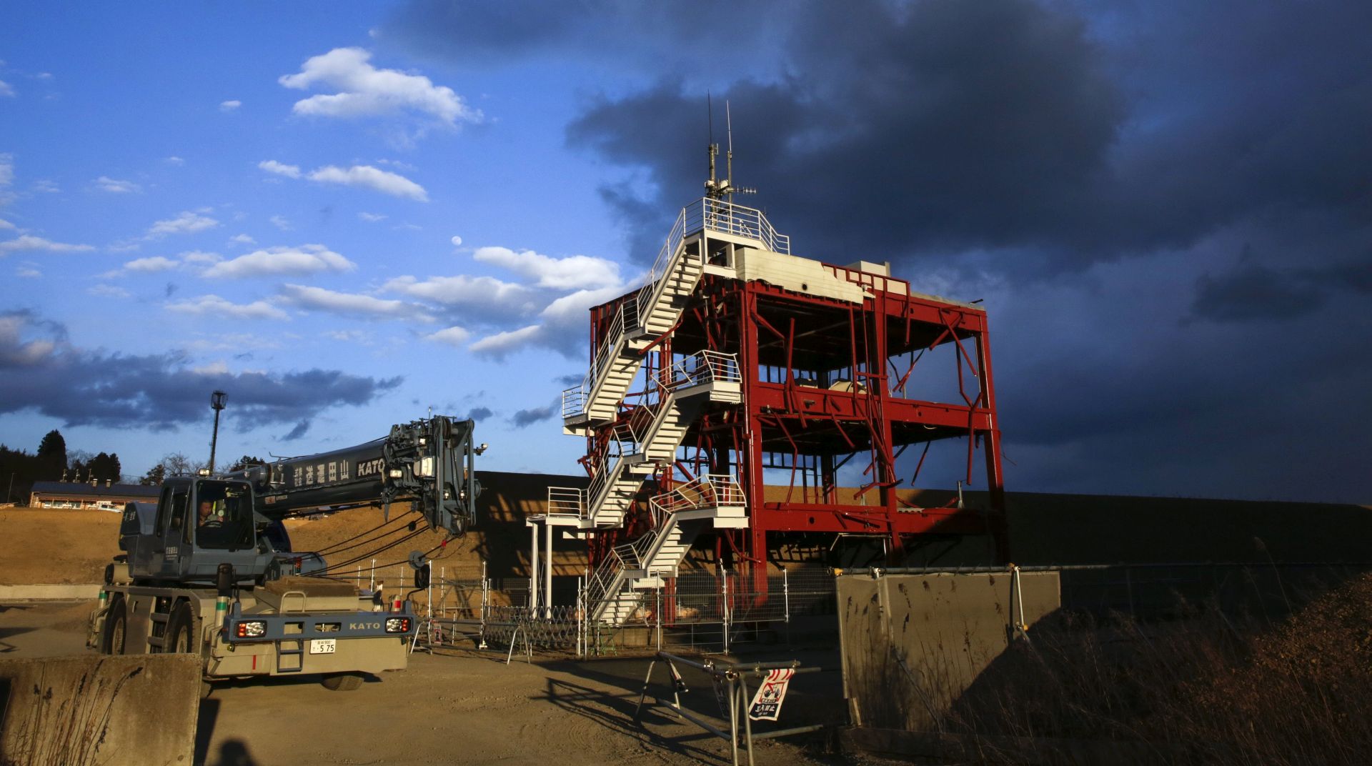 epa05840589 A crane is drives past the frame work of the disaster-prevention center of Minamisanriku town is surrounded by banks in Minamisanriku, Miyagi Prefecture, northern Japan, 10 March 2017, the eve of the sixth anniversary of the 2011 March 11 earthquake and tsunami, while the central town ground are leveling more than 10m high. Thirty officials of the town hall evacuated to the rooftop after the earthquake but only 10 officials were left after the tsunami following the earthquake. More than 800  people were killed and missing by the earthquake and tsunami in the town according to the town hall. Japan will mark the sixth anniversary of the earthquake and tsunami devastating northern Japan and Tokyo Electric Power Company's Fukushima Daiichi Nuclear Power Plant on 11 March 2017. About 20,000 people were killed and missing by the earthquake and tsunami.  EPA/KIMIMASA MAYAMA