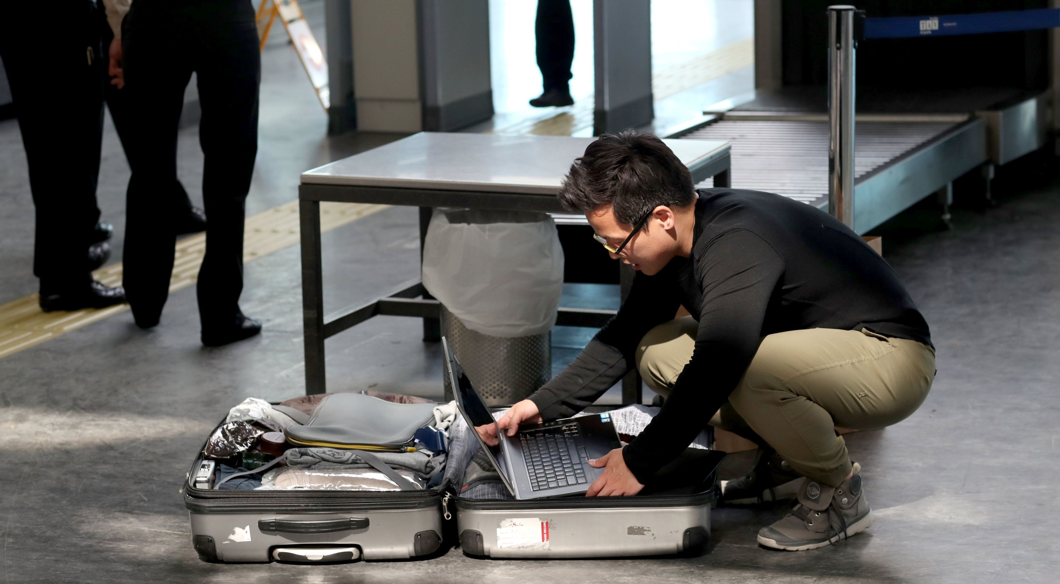epa05862908 Passengers open their luggage and show their electronic equipment at security point at the Ataturk Airport, in Istanbul, Turkey, 2017. The United State and Britain have banned some electronic devices for passengers in their carry-on cabin lugguage on flights from some airports in Turkey, the Middle East and North Africa.  EPA/SEDAT SUNA