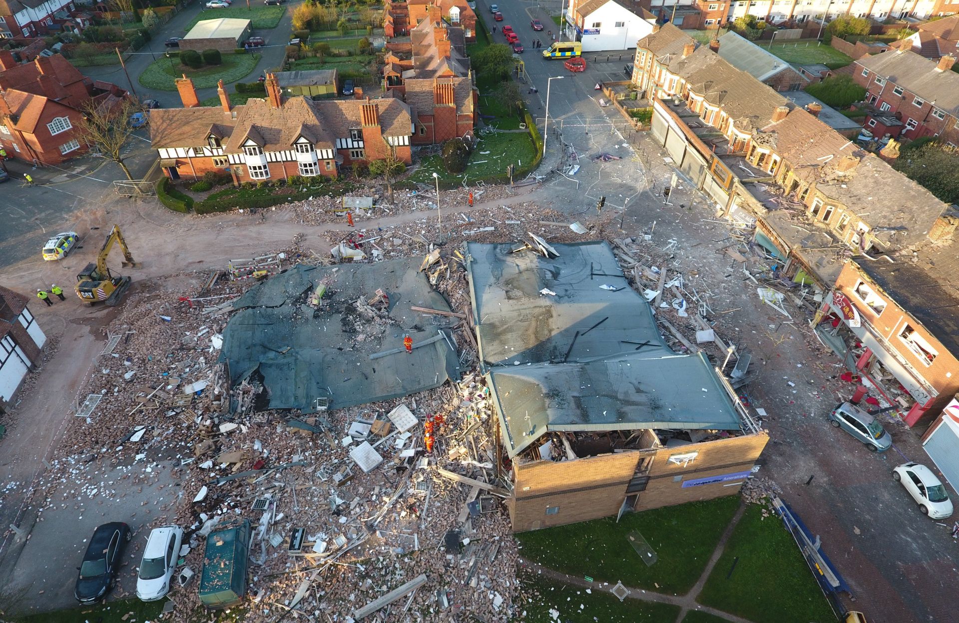 epa05871518 An aerial view 26 March 2017 over the the devastated buildings destroyed late 25 March 2017 by a an explosion in Bebington, Wirral, near Liverpool, Britain. Reports state two people have been seriously injured and 32 others hurt after several buildings collapsed in a suspected gas explosion. Houses shook and windows smashed in the blast - described as sounding like an earthquake - leaving bricks and debris strewn on roads. A number of houses in the area were evacuated and more than 100 people were moved overnight to a nearby church. A dance studio for children, which was unoccupied at the time, was destroyed.  EPA/SWNS.COM UK AND IRELAND OUT