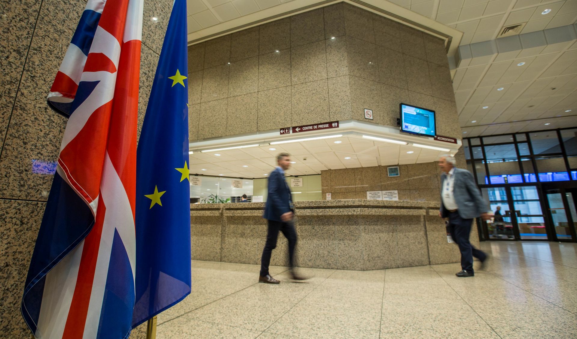 epa05876524 The British Union flag and European flag ar placed next to each other while people walk past at the EU council in Brussels, Belgium, 29 March 2017. British Prime Minister Theresa May has signed the letter giving official notice under Article 50 of the Lisbon Treaty, and which will be delivered to European Council president Donald Tusk by the British ambassador to the EU, Sir Tim Barrow later on 29 March 2017.  EPA/STEPHANIE LECOCQ