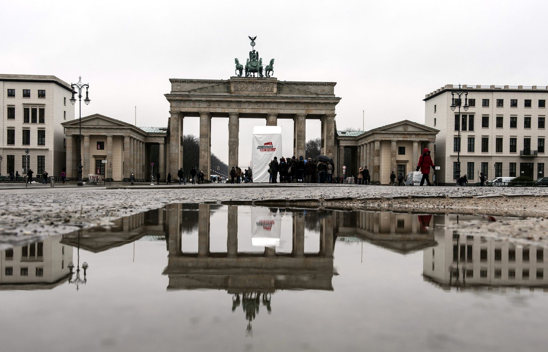 epa04595209 A booth prmoting an 2024 Olympic bid stands in front of Brandenburg Gate and the adjacent buildings reflected in a puddle of water in Berlin, Germany, 30 January 2015. Berlin is exploring a bid for the 2024 Summer Olympics.  EPA/PAUL ZINKEN