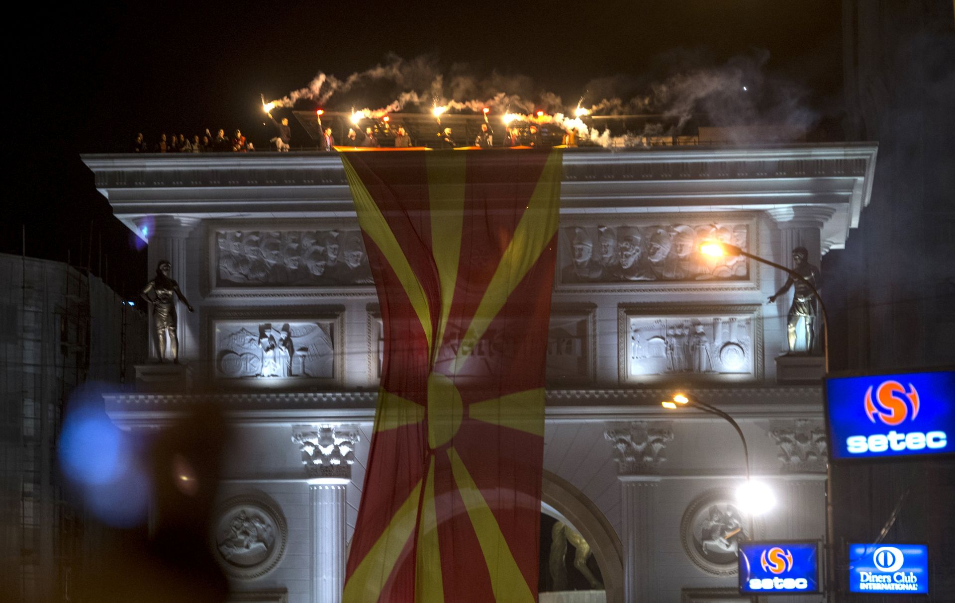 epa05821363 Supporters of the Civil Initiative for United Macedonia hold torches on the top of triumphal arc, during the protest in front of the Government building in Skopje, The Former Yugoslav Republic of Macedonia, 28 February 2017. Macedonian citizens organized by the 'Civil Initiative for United Macedonia' mobilized for protests against possible government between the opposition Social democrats and the main Albanian party, Democratic Union for Integration, claiming that their coalition deal that includes Albanian becoming an official language, will break up the country. The protest comes after VMRO-DPMNE's leader Nikola Gruevski called on the people on 26 February, to defend the country he alleges is under attack.  EPA/GEORGI LICOVSKI