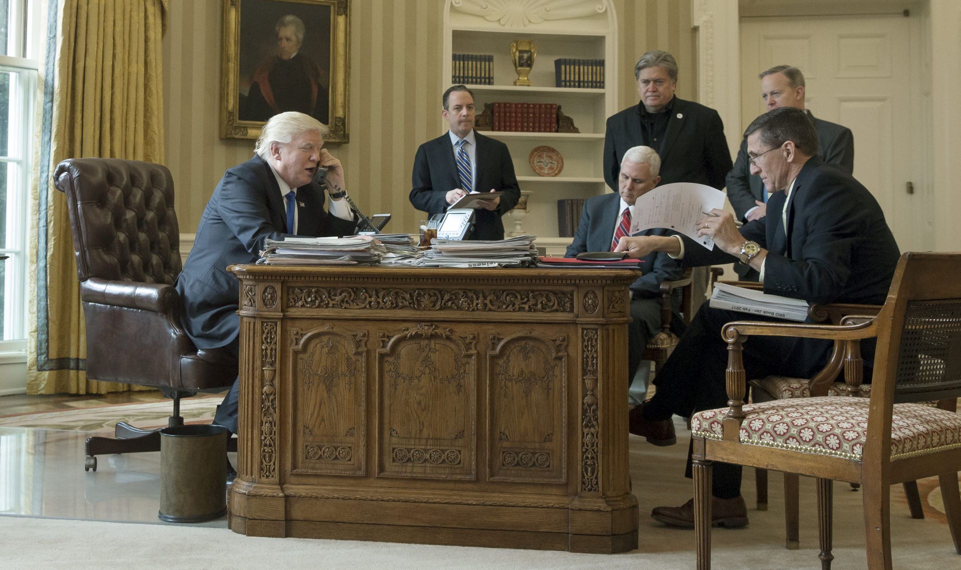 epa05757527 US President Donald J. Trump (L) speaks on the phone with President of Russia Vladimir Putin, in the Oval Office of the White House in Washington, DC, USA, 28 January 2017. President Trump has chosen the day to talk with different world leaders, significantly Russia's Vladimir Putin and Germany's Angela Merkel by telephone. Also in this picture; White House Chief of Staff Reince Priebus (2-L), US Vice President Mike Pence (3-L),  Chief Strategist and Senior Counselor Stephen Bannon (3-R), White House Press Secretary Sean Spicer (2-R) and National Security Advisor, retired Lieutenant General Michael Flynn.  EPA/MICHAEL REYNOLDS