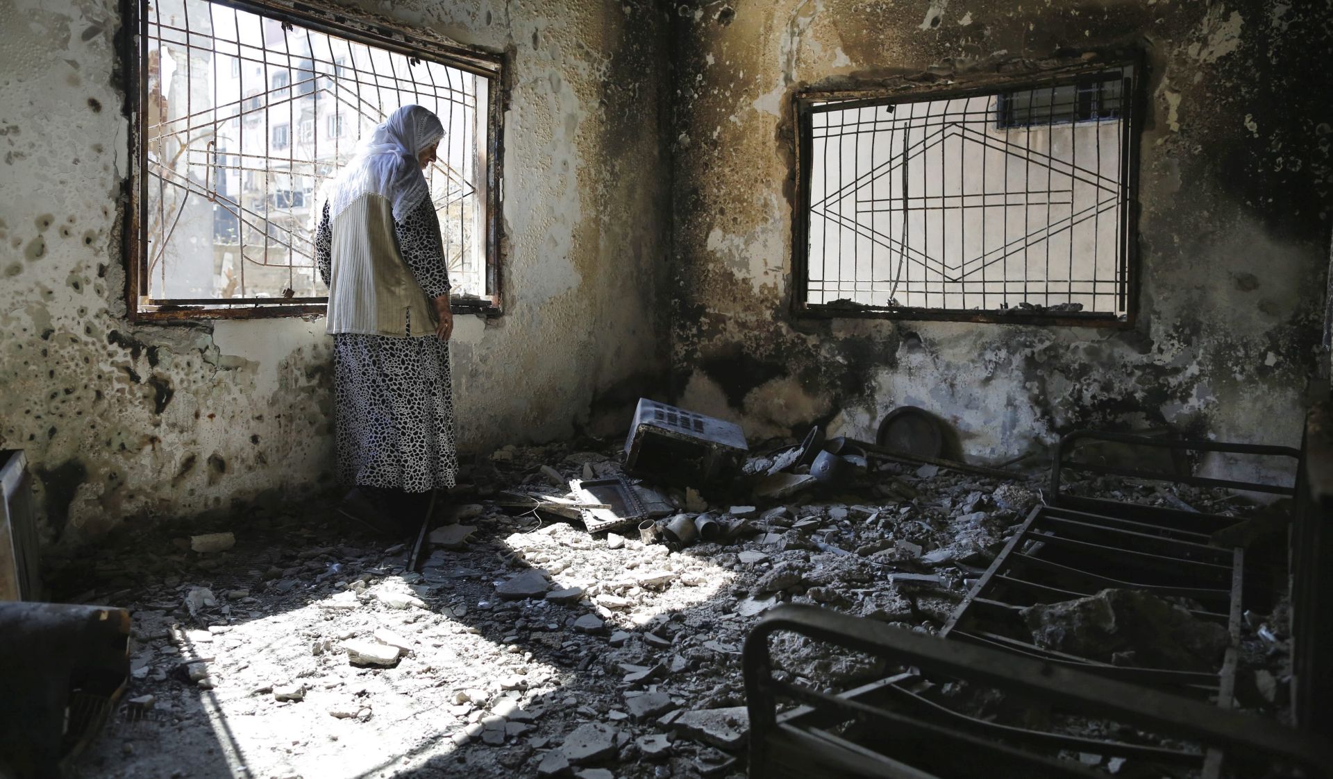 epa05192724 A Kurdish woman looks at the damage to her house, the day after clashes between Turkish special forces and PKK militants broke out on 02 March 2016, in south-east Cizre district in Sirnak, Turkey, 03 March 2016. On 01 March Turkey partially lifted a curfew on Cizre, in the mostly Kurdish south-east of the country, after 79 days of strict, round-the-clock restrictions. Tens of thousands of people have fled intense battles in the district, which intensified when the military launched a major operation in December 2015  EPA/CEM TURKEL