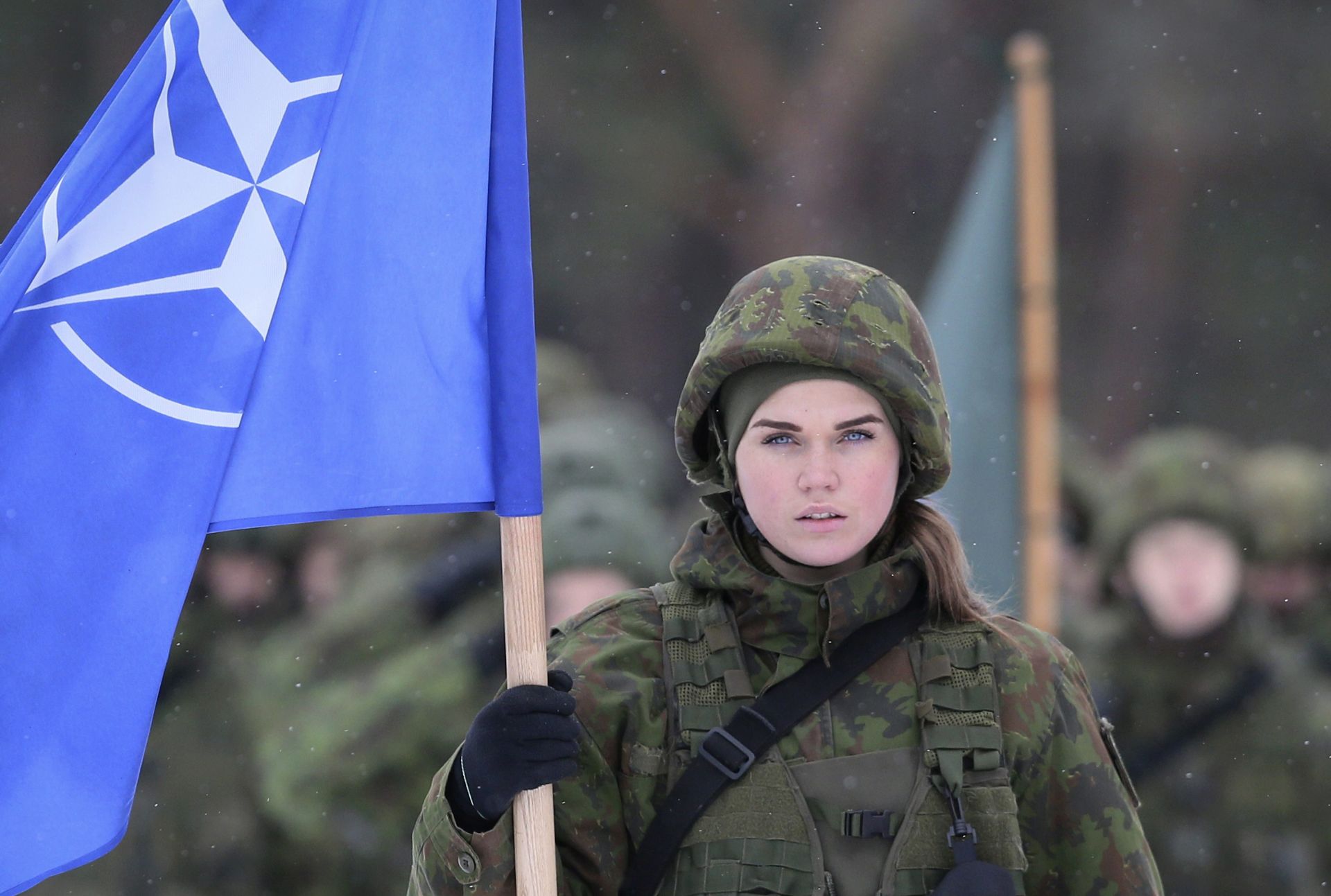 epa05656130 A female soldier presents the NATO flag during the closing ceremony of the multinational military exercise 'Iron Sword 16' near Vilnius, Lithuania, 02 December 2016. The exercise of the North Atlantic Treaty Organization (NATO) includes about 4,000 troops from Latvia, Canada, Estonia, Germany, Lithuania, Luxembourg, Poland, Romania, Britain the US, which are the same countries that will contribute to the four NATO battalions in the Baltic States and Poland in 2017.  EPA/OLIVIER HOSLET