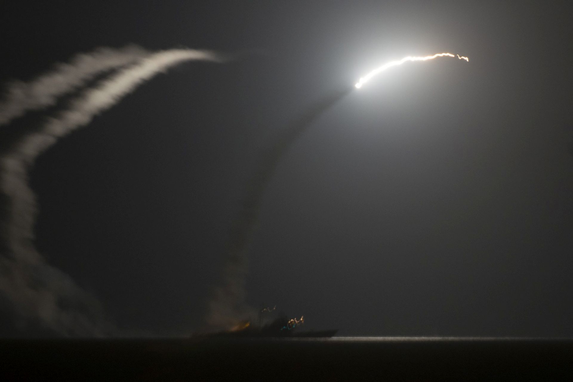 epa04412973 A handout picture released by the US Navy shows the guided-missile cruiser USS Philippine Sea (CG 58) launching a Tomahawk cruise missile against IS (Islamic State) targets in Syria, as seen from the aircraft carrier USS George H.W. Bush (CVN 77) in the Arabian Gulf, 23 September 2014. The United States and allied forces launched airstrikes against Islamic State militants in Syrian territory for the first time, the Pentagon said. The bombings were the first against Islamic State militants in Syria. The US had previously bombed Islamic State targets in Iraq, but said that it would pursue the group in Syria if necessary.  EPA/ERIC GARST/US NAVY/HANDOUT  HANDOUT EDITORIAL USE ONLY