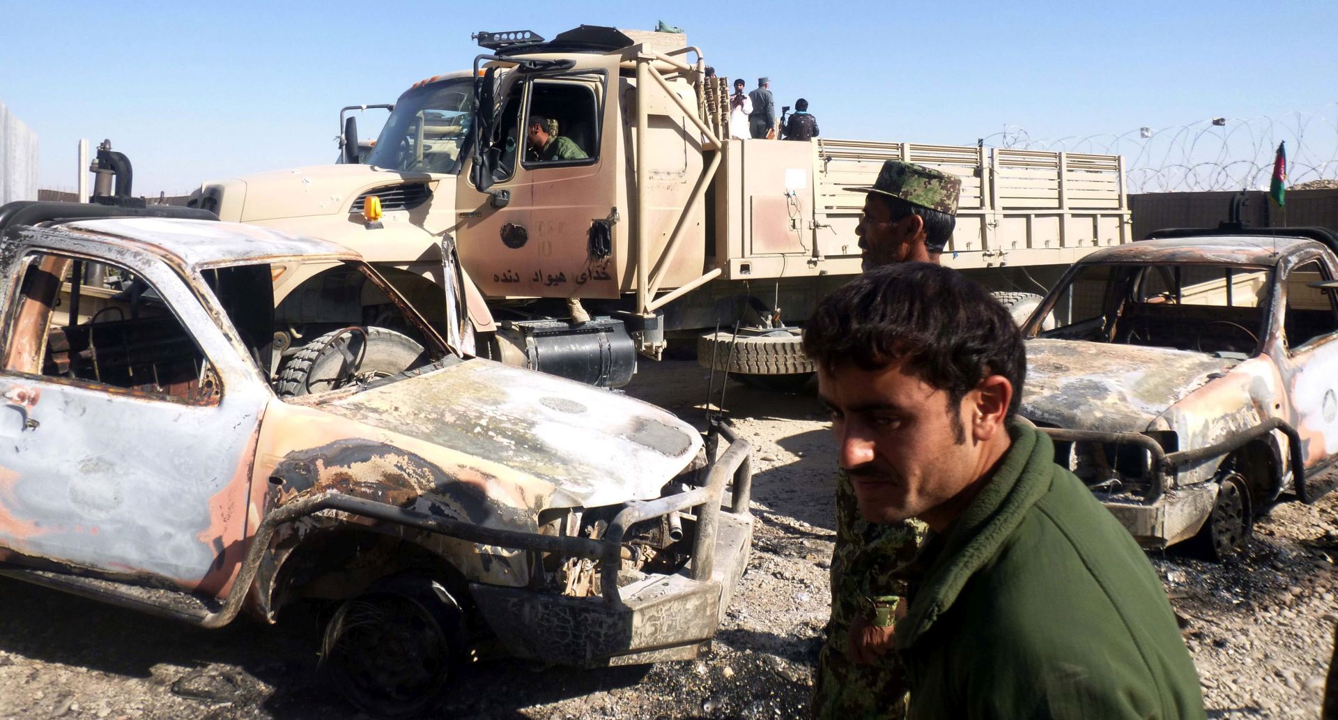 epa04510705 Afghan security officials inspect the site of a bomb blast that targeted a former NATO base in Helmand Province, Afghanistan, 01 December 2014. At least five Afghan army personnel were killed, and three others wounded, when Taliban fighters attacked a former NATO base in southern Afghanistan that had recently been handed over to the Afghan army, reported the Defense Ministry on 29 November.  EPA/WATAN YAR