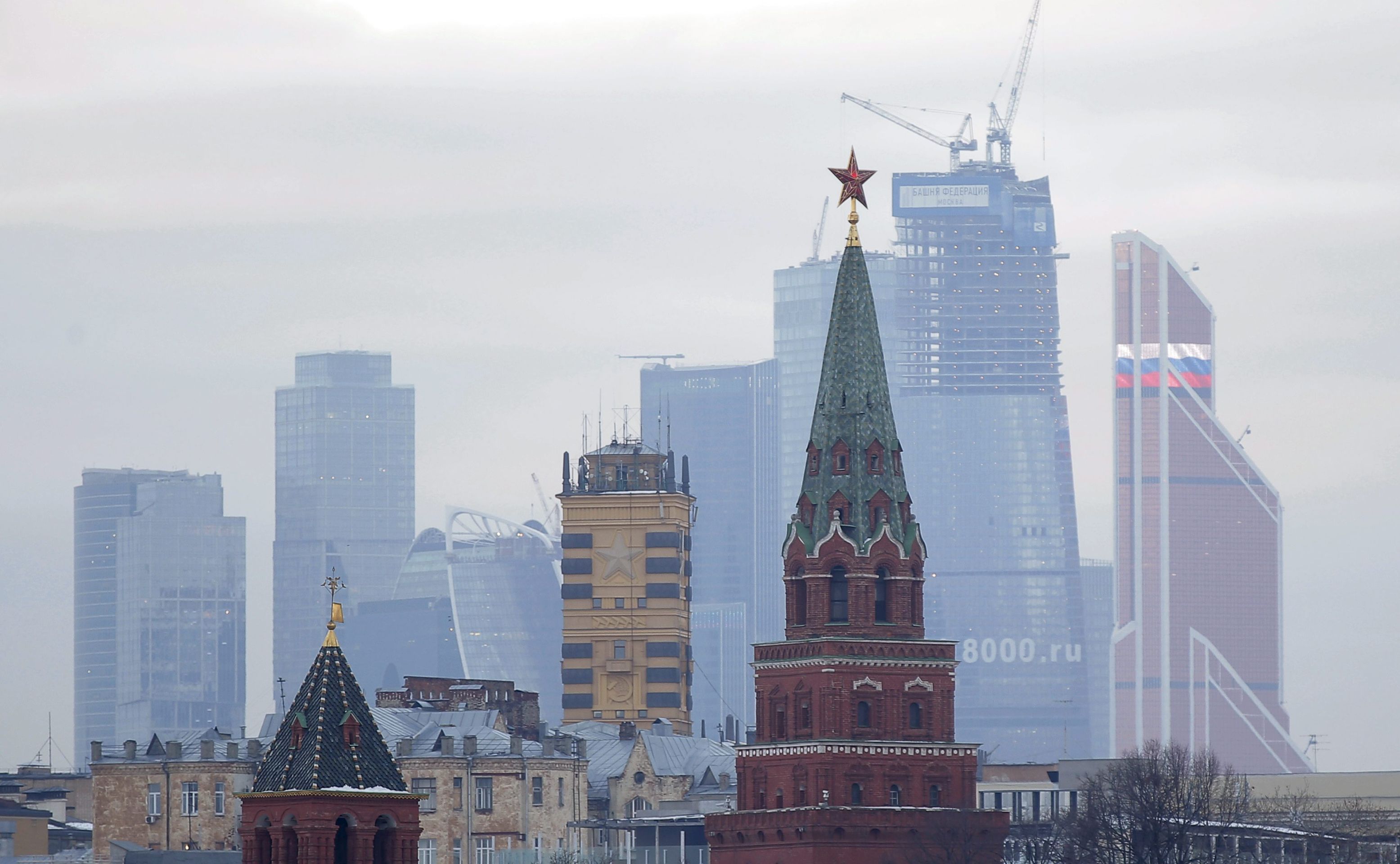 epa04530328 A view of the Moscow Kremlin (front) and the Moscow International Business Centre, also known as Moskva City (back) in Moscow, Russia, 15 December 2014. The Russian ruble dropped to all-time low against the dollar at 58,35 and the euro at 72,66.  EPA/MAXIM SHIPENKOV