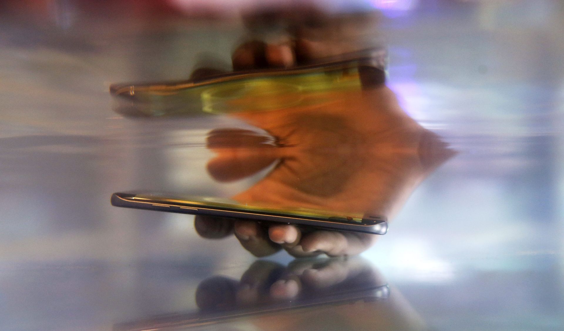 epa05561771 A visitor demonstrates the waterproof function of Samsung's new smartphone Galaxy S7 Edge at Thailand Mobile Expo 2016 in Bangkok, Thailand, 29 September 2016. Mobile handsets and smart devices are launched at the country's biggest phone showcase aimed to expand the already strong growth of the cell phone market which now Thailand has an estimated of more than 20 million of smartphone users.  EPA/RUNGROJ YONGRIT