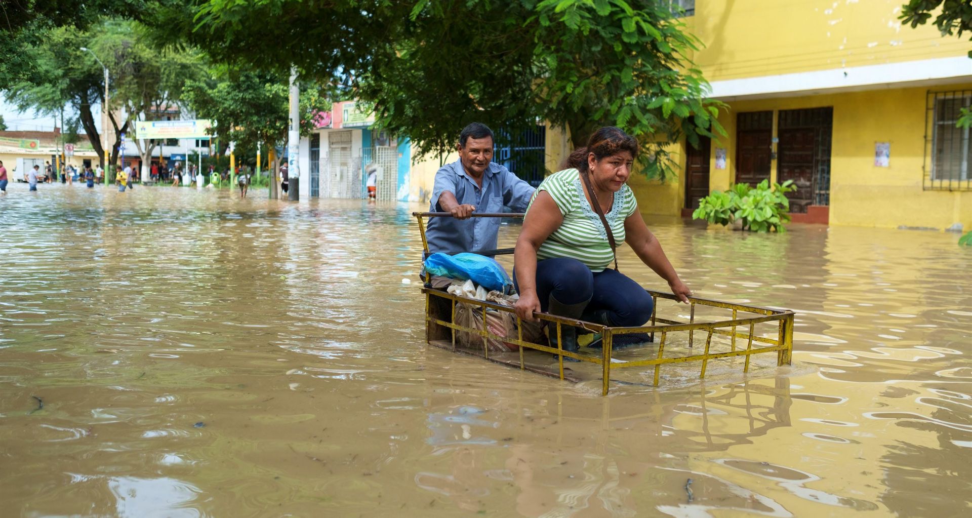 epa05874364 Two people try to advance along a street flooded by the Piura river in Piura, Peru, 27 March 2017. The city of Piura, more than 1,000 kilometers north of Lima, was flooded this morning by the overflow of the river of the same name, which reached the streets of the historic center, local media reported. Peru has been facing a climate emergency since December, caused by the phenomenon of 'El Nino Costero', which has so far left 90 dead, 20 missing, 347 injured and 120,899 people affected.  EPA/Edwin Zapata Alvarado