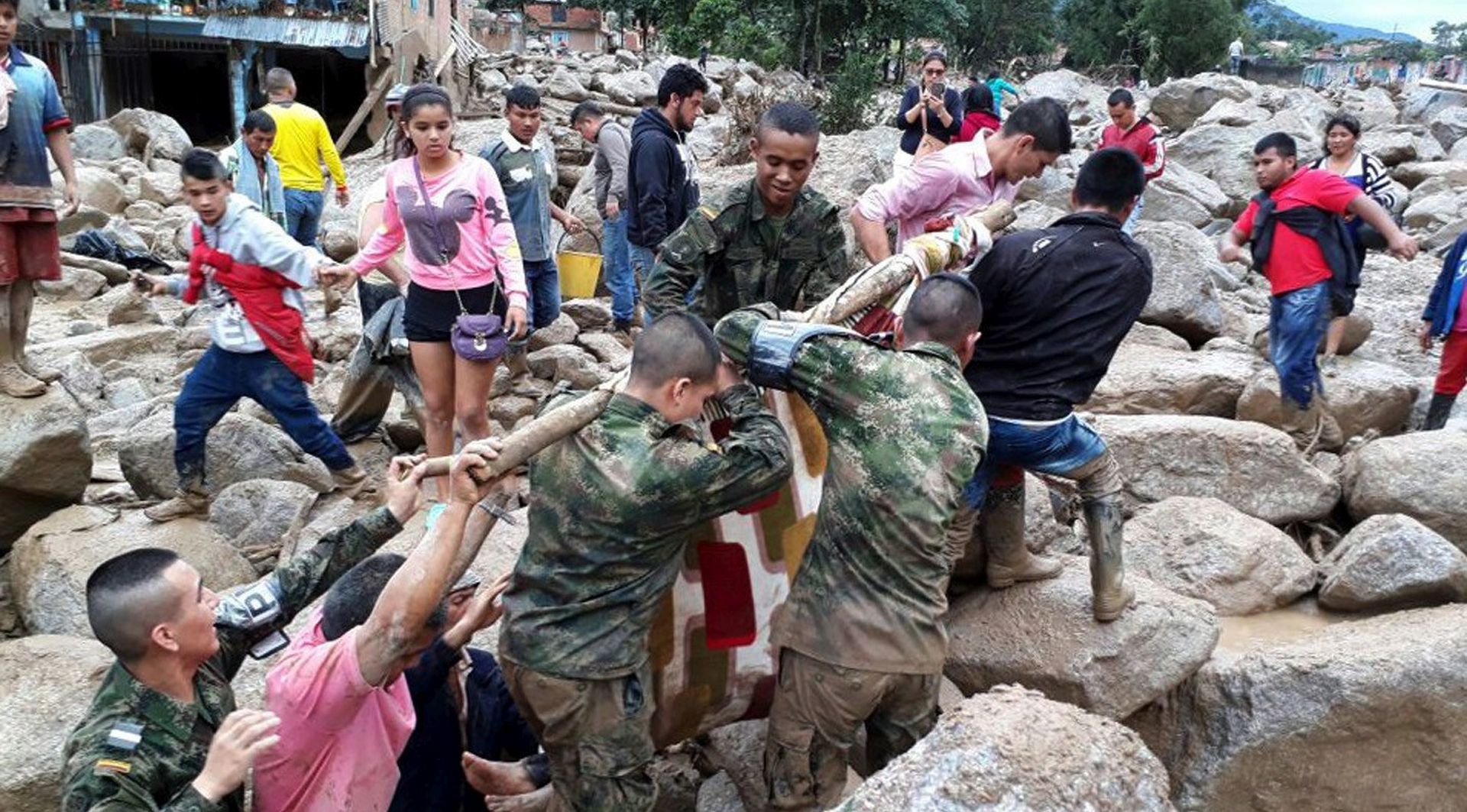 epa05883118 A handout photo made available by the Colombian Army shows soldiers and inhabitants evacuating a victim after a landslide in Mocoa, province of Putumayo, Colombia, on 01 April 2017. At least 15 people died and dozens were injured in a landslide that ocurred the previous night in Mocoa after several rivers overflowed due to heavy rains.  EPA/COLOMBIAN ARMY / HANDOUT  HANDOUT EDITORIAL USE ONLY/NO SALES