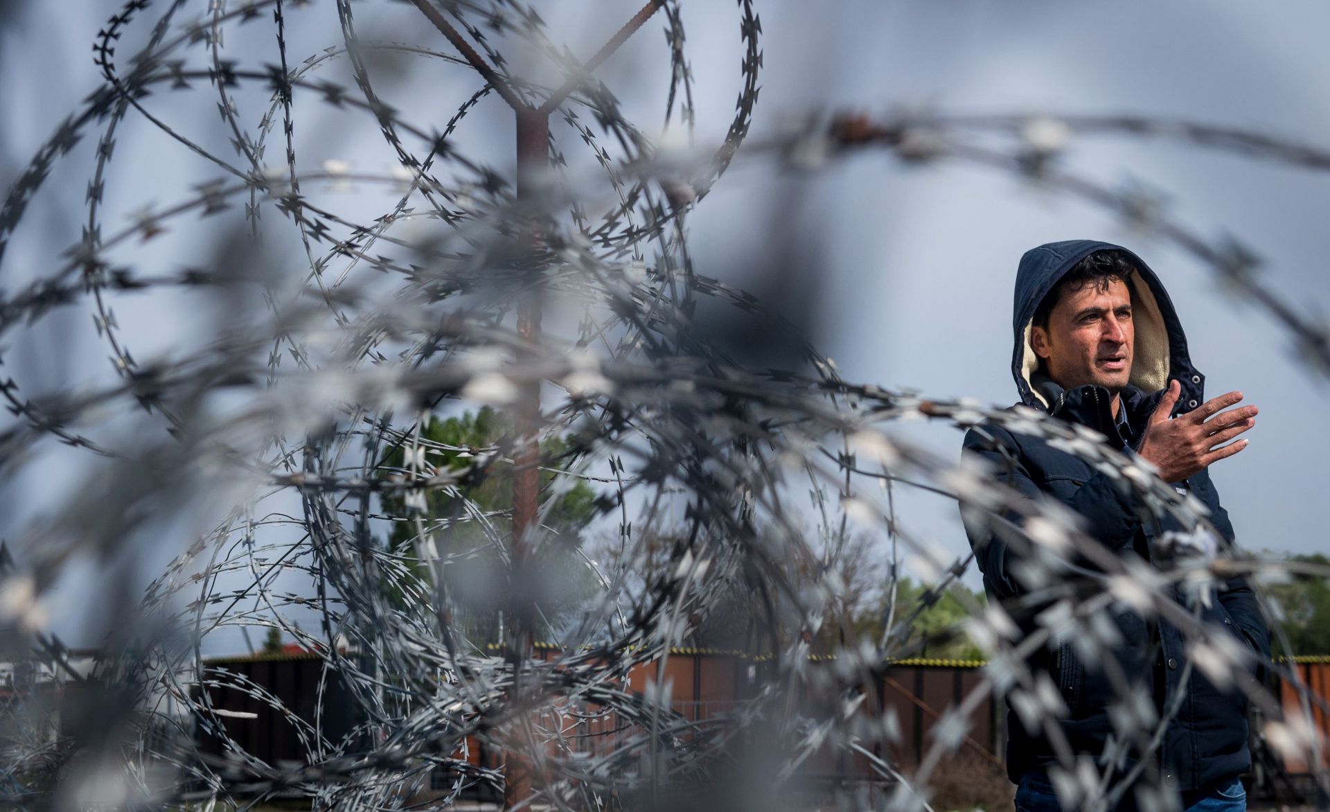 epa05891805 A refugee speaks to journalists behind a barbed wire on the Serbian side of the border at Hungary's southern border with Serbia near Tompa, 169 kms southeast of Budapest, Hungary, 06 April 2017. The migrant transit complex on the Hungarian side of the border has been expanded to become one of two new detention centers for asylum seekers in the Hungarian transit zone and contains shipping containers that are used to automatically detain migrants in the transit zone while their claims are investigated.  EPA/SANDOR UJVARI HUNGARY OUT