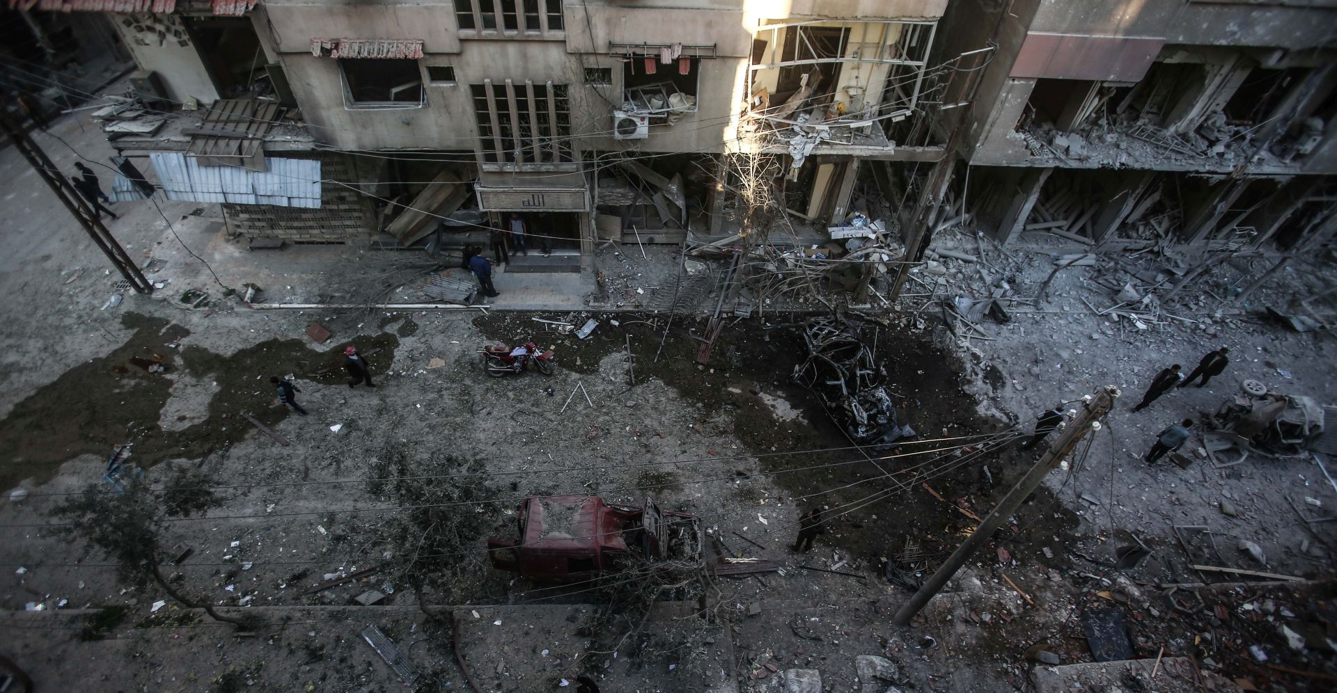 epa05895940 People inspect damged buildings after an airstike on Douma, Syria, 07 April 2017. There were more than 15 casualties as the Syrian military continued their bombardment of opposition-held areas around Damascus.  EPA/Mohammed Badra