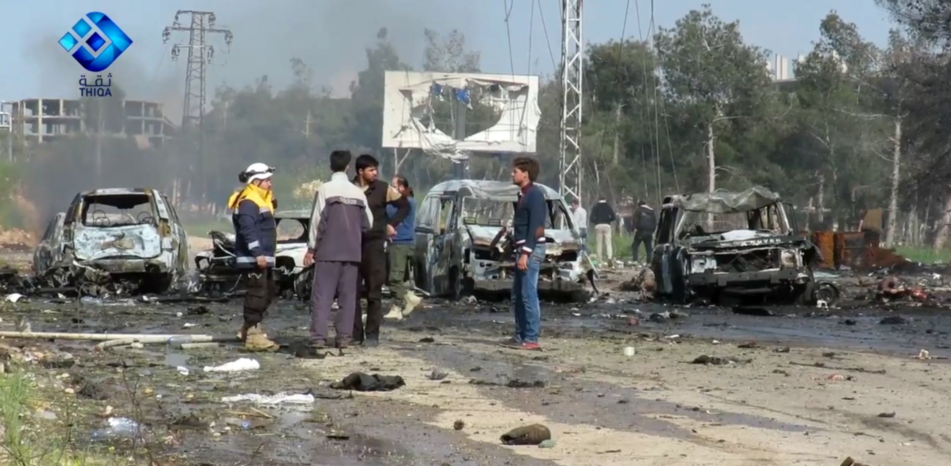 epa05909736 A handout photo made available by Thiqa News Agency (TNA) showing rescue and media personnel at the scene of a car bomb attack that targeted buses evacuating civilians from besieged towns, al-Rashideen area, west of Aleppo, Syria, 15 April 2017. According to media reports at least 24 people were killed when a suicide car attacked buses transporting civilians from Kefraya and al-Foua'a towns to al-Rashideen area near Aleppo.  EPA/THIQA NEWS AGENCY / HANDOUT  HANDOUT EDITORIAL USE ONLY/NO SALES