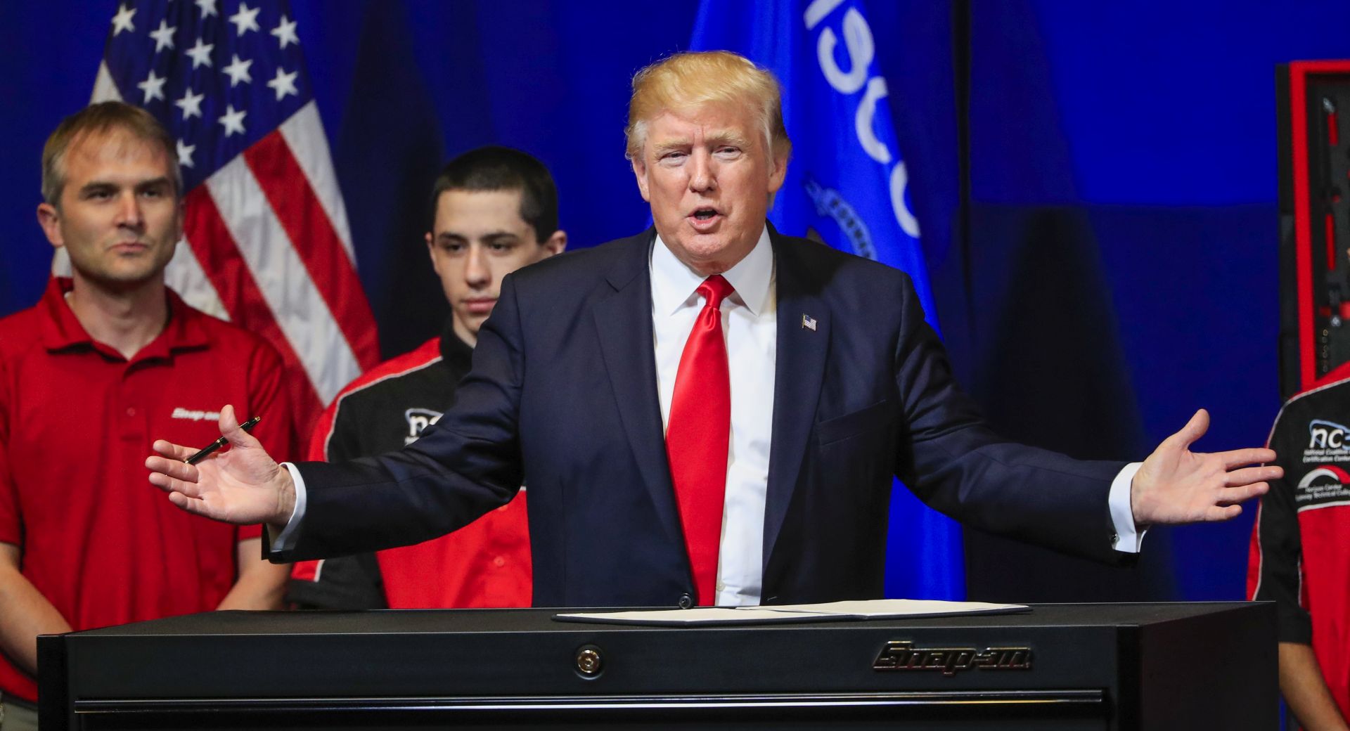 epa05914035 US President Donald J. Trump prepares to sign an executive order after speaking at the Snap-on Tools headquarters in Kenosha, Wisconsin, USA, 18 April 2017. Trump spoke on his plan to 'Buy American - Hire American' and signed an executive order to protect American workers and make it harder for foreign contractors to bid on US government endeavors according to administration officials.  EPA/TANNEN MAURY