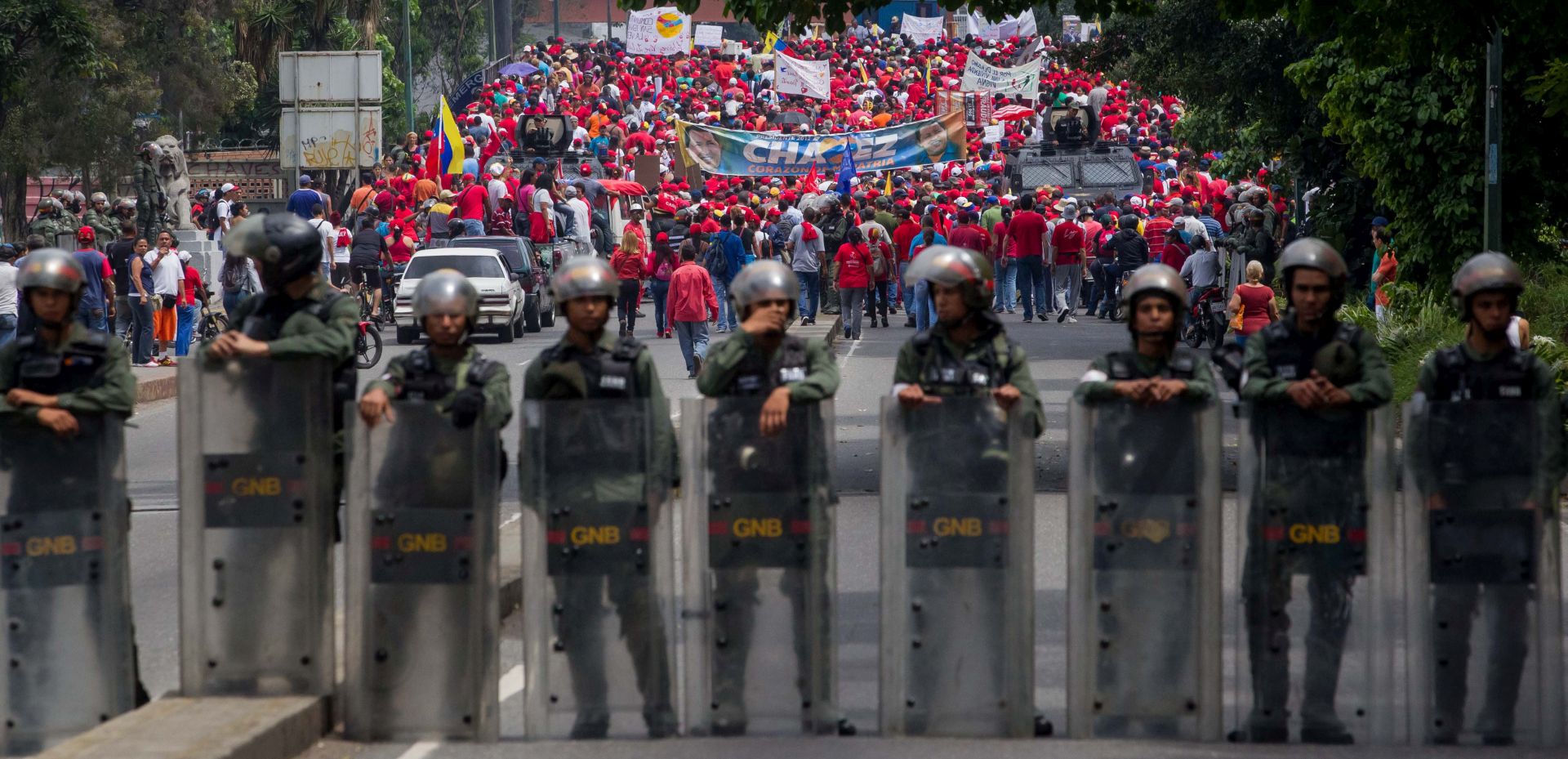 epa05915970 Venezuelan government supporters line up behind members of the National Guard of Venezuela during a rally in Caracas, Venezuela, 19 April 2017. Venezuela is the scene of massive protests for both government supporters and opposition groups heightening tension throughout the country.  EPA/CRISTIAN HERNANDEZ