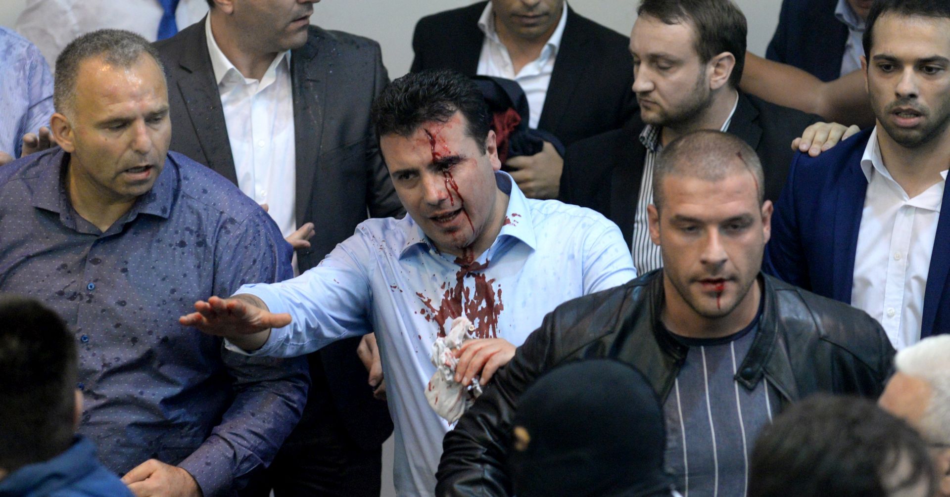 epa05931625 Zoran Zaev (C), the leader of Social Democratic Union of Macedonia with blood on his face tries to leave the Parliament after protestors attacked him after they stormed the Macedonian Parliament in Skopje, The Former Yugoslav Republic of Macedonia on 27 April 2017. President Ivanov didn't give the mandate for a new government, although Zoran Zaev (the leader of SDSM) provided a list of signatures, guaranteeing parliamentary majority he rejected giving him the mandate with explanation that the coalition between Zaev and the Albanian parties (with their platform for two official languages in the country) would destroy the constitutional order in the country.  EPA/STR