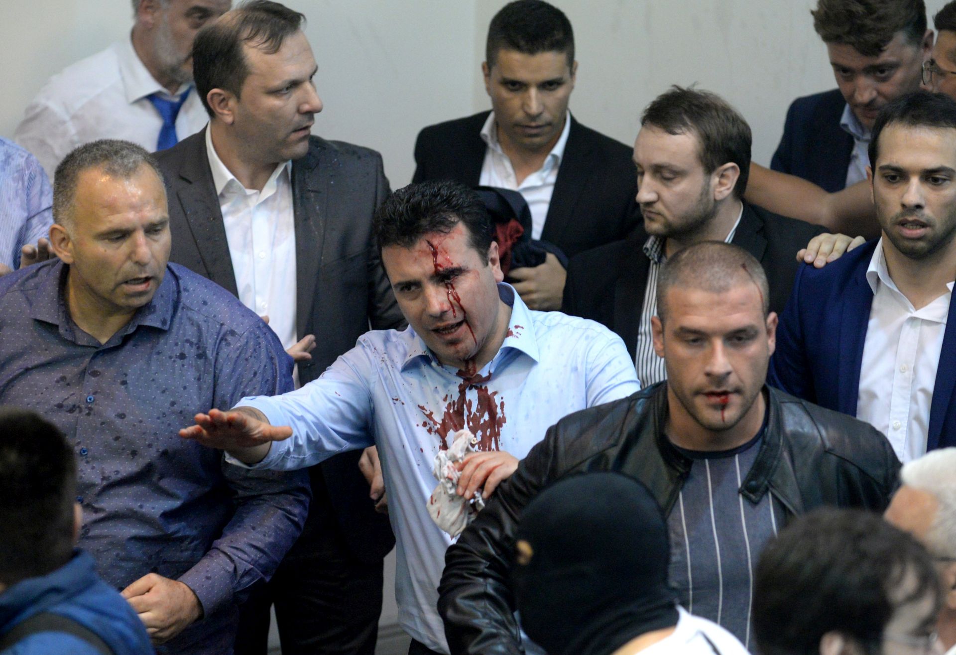 epa05931625 Zoran Zaev (C), the leader of Social Democratic Union of Macedonia with blood on his face tries to leave the Parliament after protestors attacked him after they stormed the Macedonian Parliament in Skopje, The Former Yugoslav Republic of Macedonia on 27 April 2017. President Ivanov didn't give the mandate for a new government, although Zoran Zaev (the leader of SDSM) provided a list of signatures, guaranteeing parliamentary majority he rejected giving him the mandate with explanation that the coalition between Zaev and the Albanian parties (with their platform for two official languages in the country) would destroy the constitutional order in the country.  EPA/STR