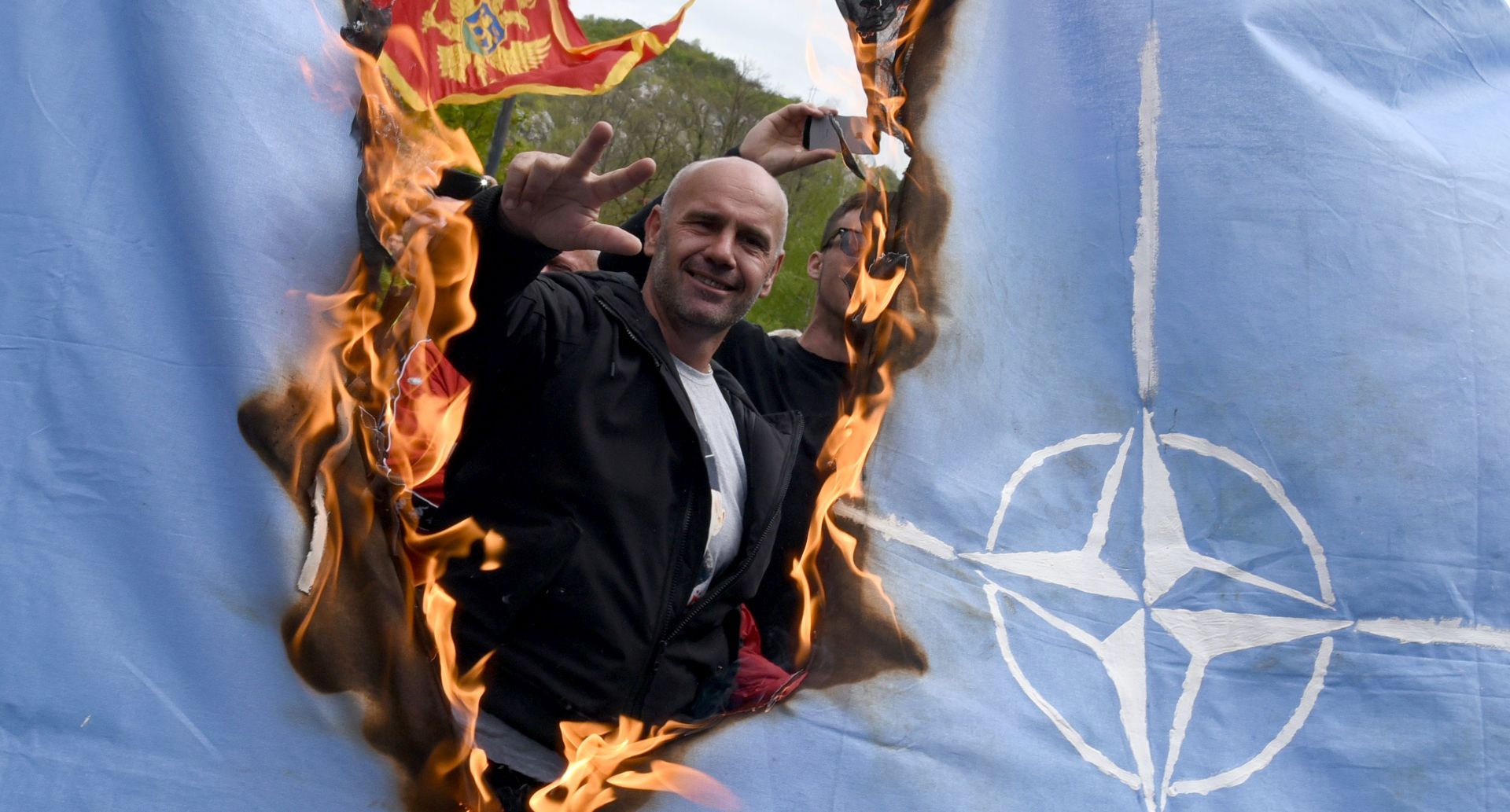 epa05933129 Protesters burn a NATO flag while Montenegro's parliament discusses the ratification of a NATO membership agreement in Cetinje, Montenegro, 28 April 2017. Montenegro's Parliament formally approved becoming a member of NATO on Friday in an historic session.  EPA/BORIS PEJOVIC