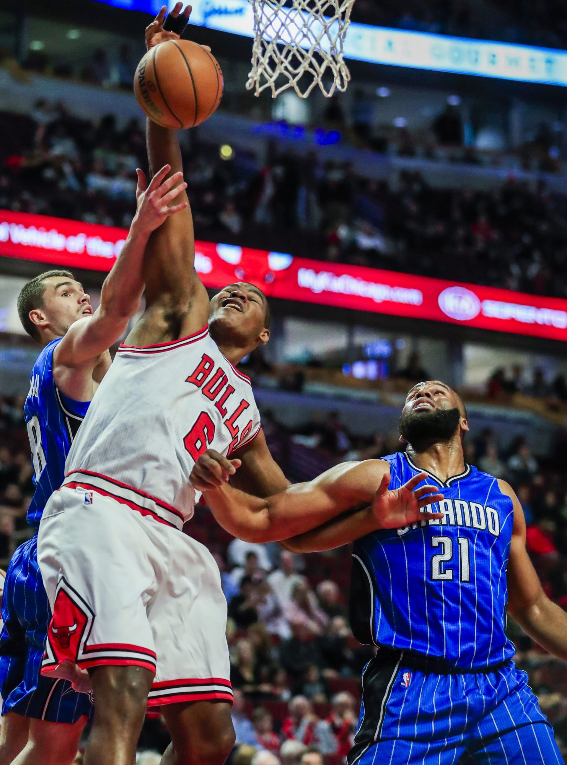 epa05621748 Chicago Bulls forward Cristiano Felicio of Brazil (C) battles for a reboiund with Orlando Magic guard Mario Hezonja of Croatia (L) and Orlando Magic forward Arinze Onuaku (R) in the second half of their NBA game at the United Center in Chicago, Illinois, USA, 07 November 2016. The Bulls defeated the Magic.  EPA/TANNEN MAURY