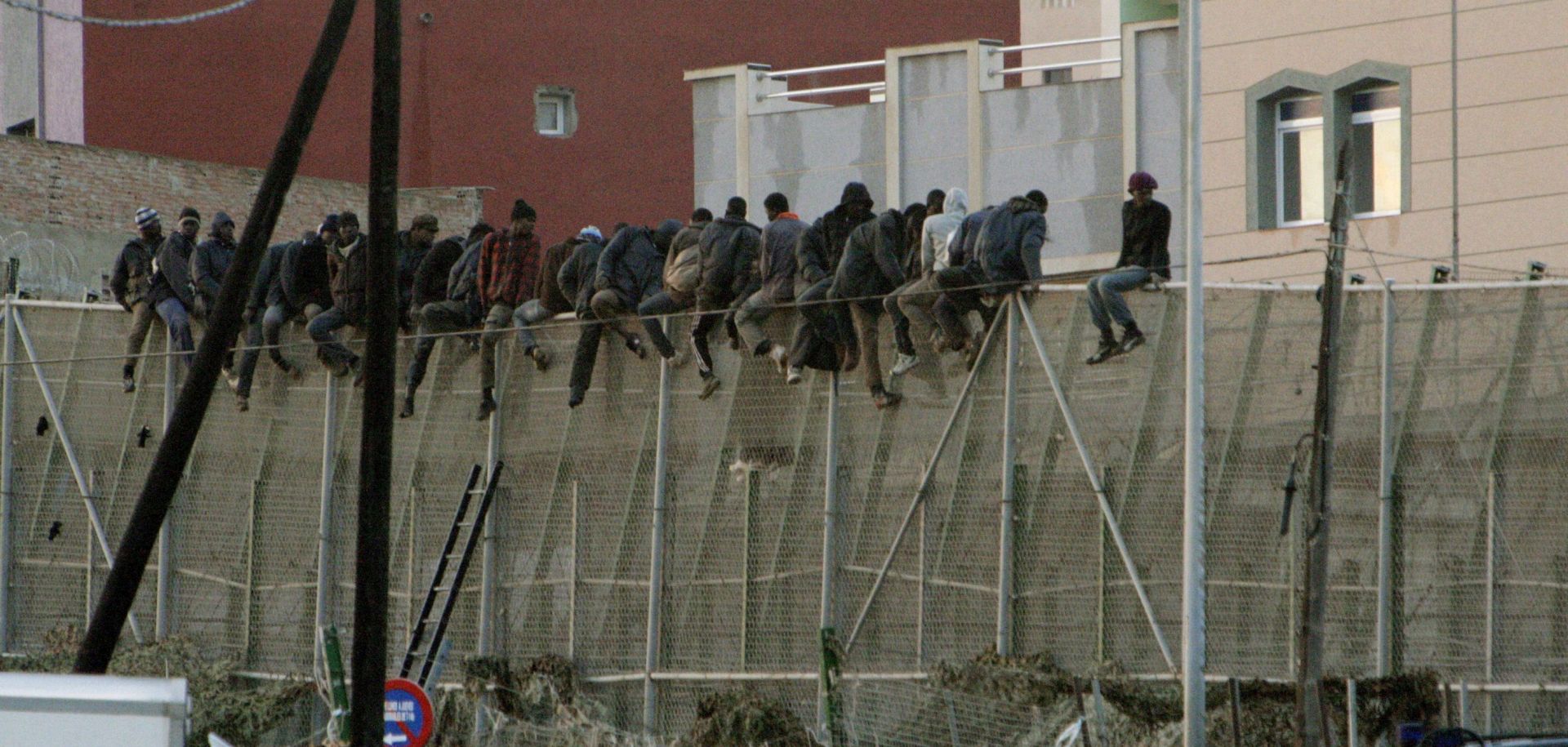 epa04542757 Some 30 sub-Saharan people wait on top of a border fence as they try to reach the Spanish enclave of Melilla, northern Africa, early 30 December 2014. Around 150 or 200 people took part in the action and some 70 sub-Saharan of them managed to reach Melilla.  Melilla, along with the town of Ceuta, is situated in North Africa but belongs to Spain. They are the main entry points for people hoping to reach Europe - a position that has strained local resources far beyond their capacity. According to the Spanish government delegation to Melilla, 14,000 people have tried to scale the barricade until mid-December 2014. Of those, only about 2,000 have reached the Spanish side.  EPA/FRANCISCO G. GUERRERO