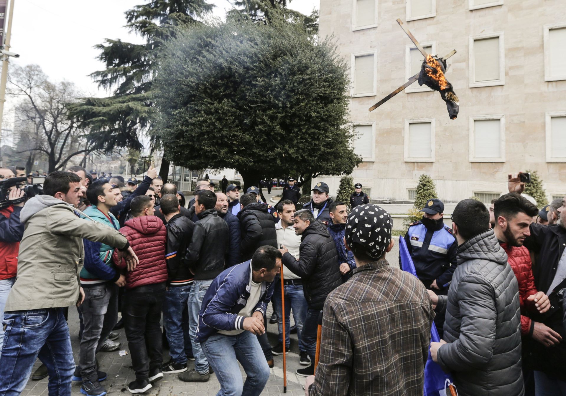 epa05801641 Protesters throw a blazing object at the police protecting the Government building as some thousands of Albanians demonstrated in front of a Government building in Tirana, Albania, 18 February 2017.  The protest, called by opposition Albanian Democratic party, four months before the general elections, was to protest against the present administration's alleged failures.  EPA/ARMANDO BABANI