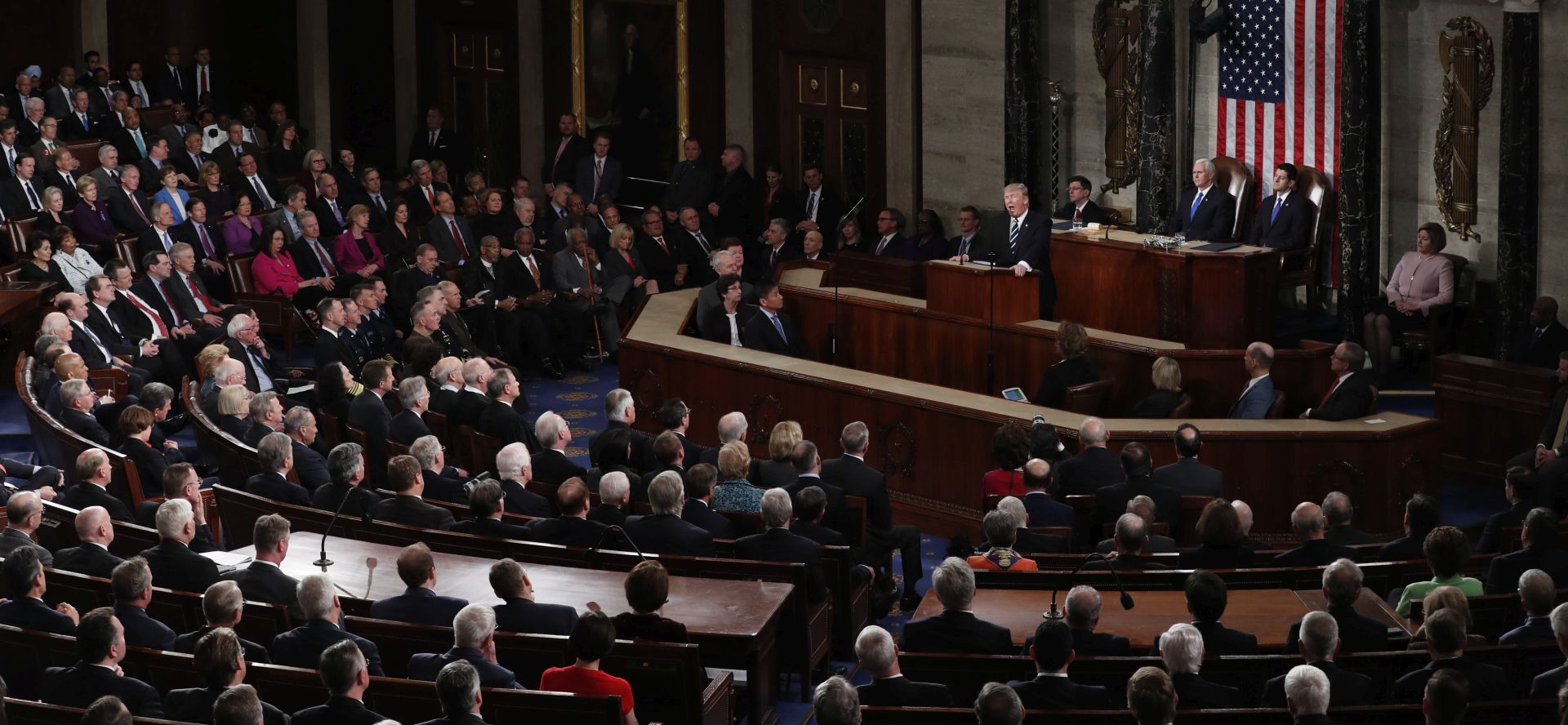 epa05821906 US President Donald J. Trump delivers his first address to a joint session of Congress from the floor of the House of Representatives in Washington, DC, USA, 28 February 2017.  Traditionally the first address to a joint session of Congress by a newly-elected president is not referred to as a State of the Union. Speaker of the House Paul Ryan (R) and US Vice President Mike Pence (L) look on.  EPA/MICHAEL REYNOLDS