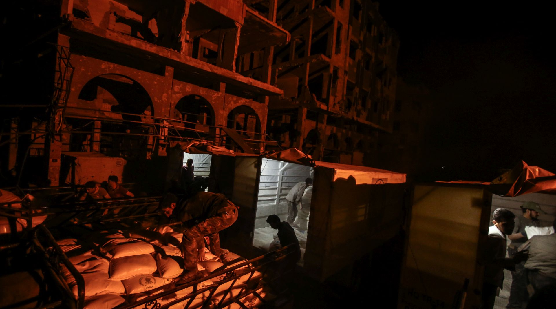 epa05941247 Workers empty a truck bringing humanitarian aid after it arrived under the supervision of the United Nations (UN), the Syrian Arab Red Crescent (SARC) and the International Committee of the Red Cross (ICRC), in Douma, Syria, 02 May 2017. According to the ICRC, an aid convoy entered the besieged town of Douma late at night on 02 May, the first time since October, bringing food and medical supplies for 35,000 people.  EPA/MOHAMMED BADRA