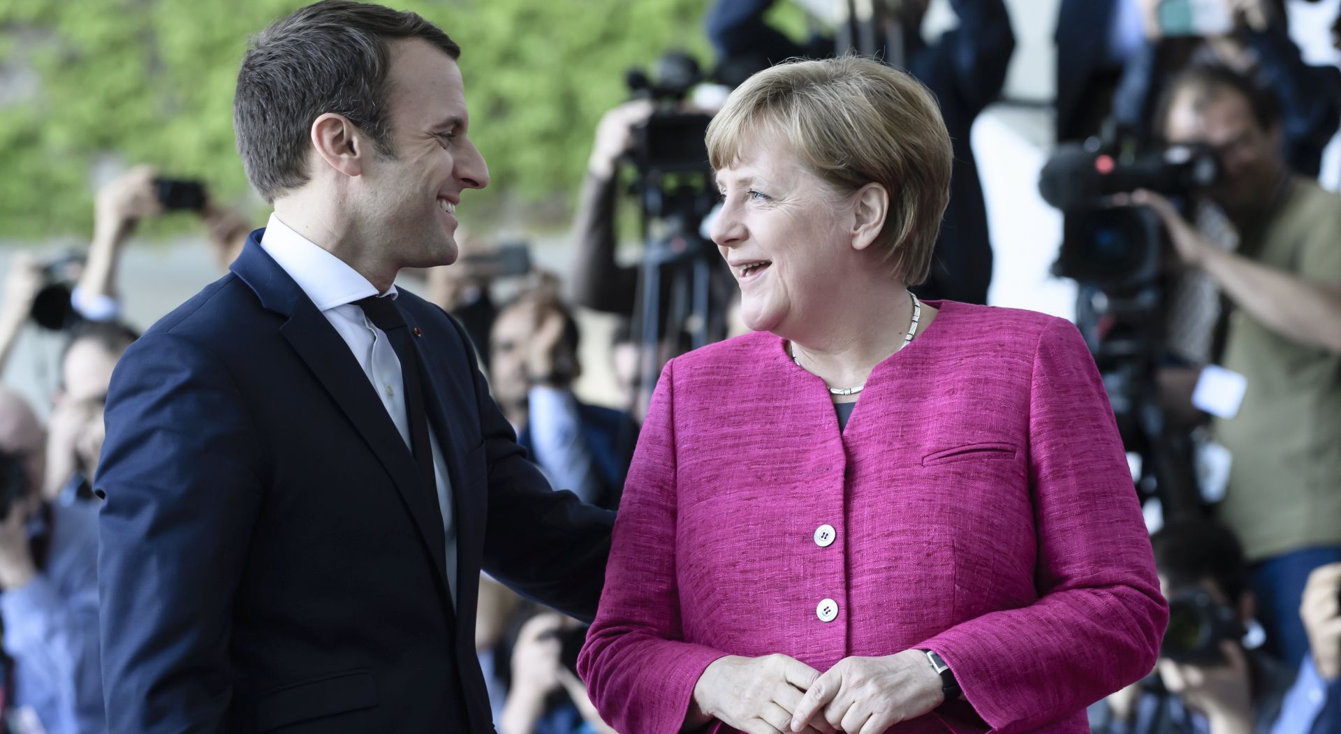 epa05966469 German Chancellor Angela Merkel (R) and newly elected French President Emmanuel Macron (L) talk on his arrival at the German Chancellery in Berlin, Germany, 15 May 2017. The French President is on his inaugural foreign visit to Germany.  EPA/CARSTEN KOALL