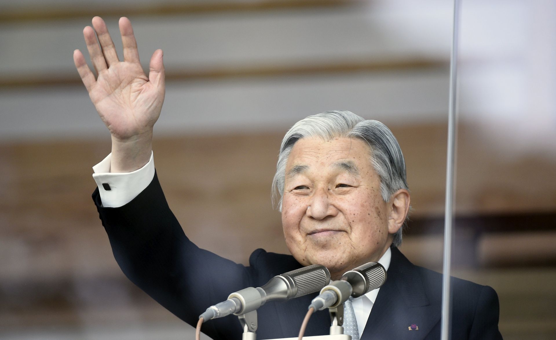 epa05973330 (FILE) - Japan's Emperor Akihito waves to well-wishers through a bullet-proof glass from a balcony during the New Year's public appearance at the Imperial Palace in central Tokyo, Japan, 02 January 2015 (reissued 19 May 2017). Japan's cabinet on 19 May 2017 approved a bill, that if passed by the parliament, would allow Akihito to abdicate as Emperor and pass on his duties to the Crown Prince Naruhito.  EPA/FRANCK ROBICHON