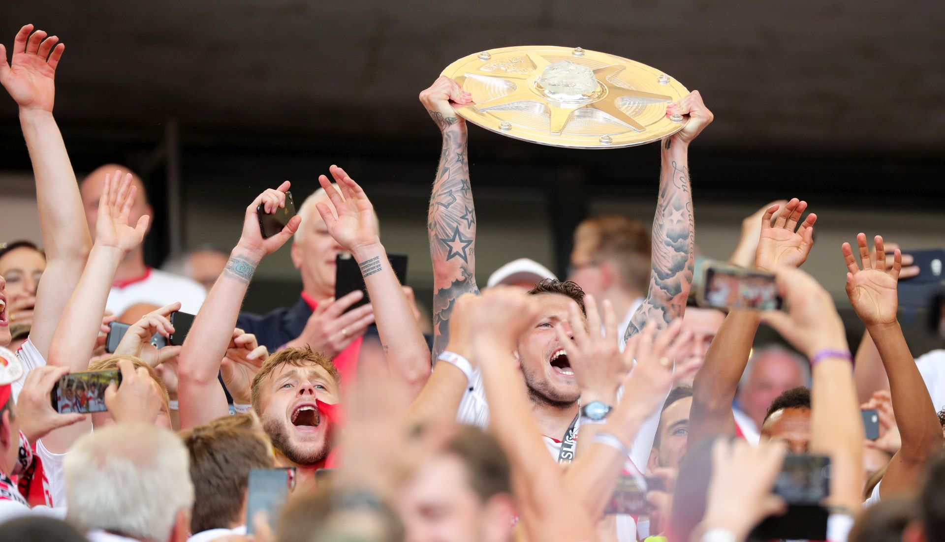 epa05979184 Stuttgart's Daniel Ginczek (C) lifts the trophy for winning the Bundesliga 2nd division title after the German Bundesliga 2nd division soccer match between VfB Stuttgart and Wuerzburger Kickers in Stuttgart, Germany, 21 May 2017. Stuttgart is promoted to the Bundesliga's first division.  EPA/ARMANDO BABANI (EMBARGO CONDITIONS - ATTENTION: Due to the accreditation guidelines, the DFL only permits the publication and utilisation of up to 15 pictures per match on the internet and in online media during the match.)