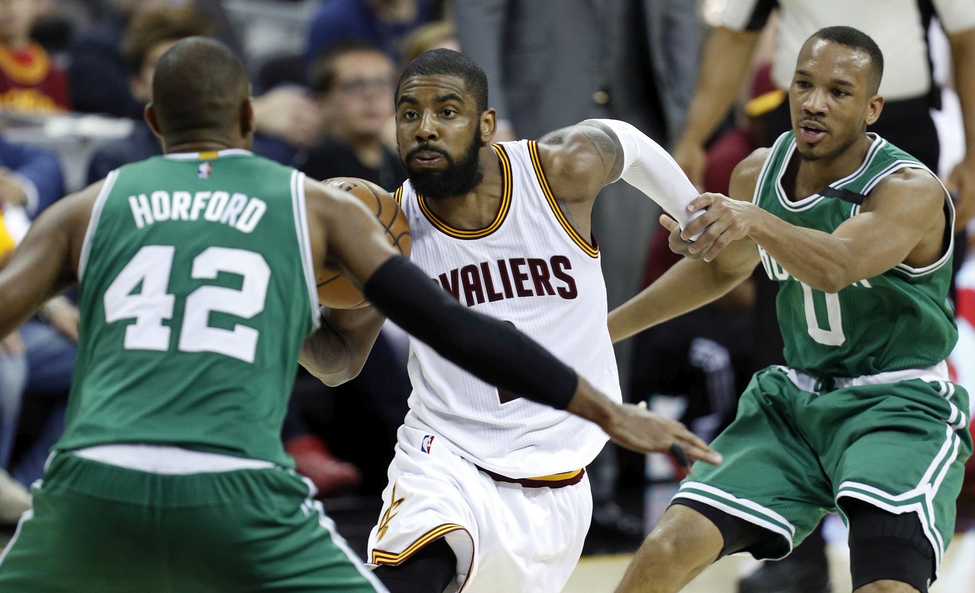 epa05980568 Boston Celtics center Al Horford of the Dominican Republic (L) and Boston Celtics guard Avery Bradley (R) defends against Cleveland Cavaliers guard Kyrie Irving (C) during the second half of game three of the NBA Eastern Conference Finals at Quicken Loans Arena in Cleveland, Ohio, USA, 21 May 2017.  EPA/DAVID MAXWELL