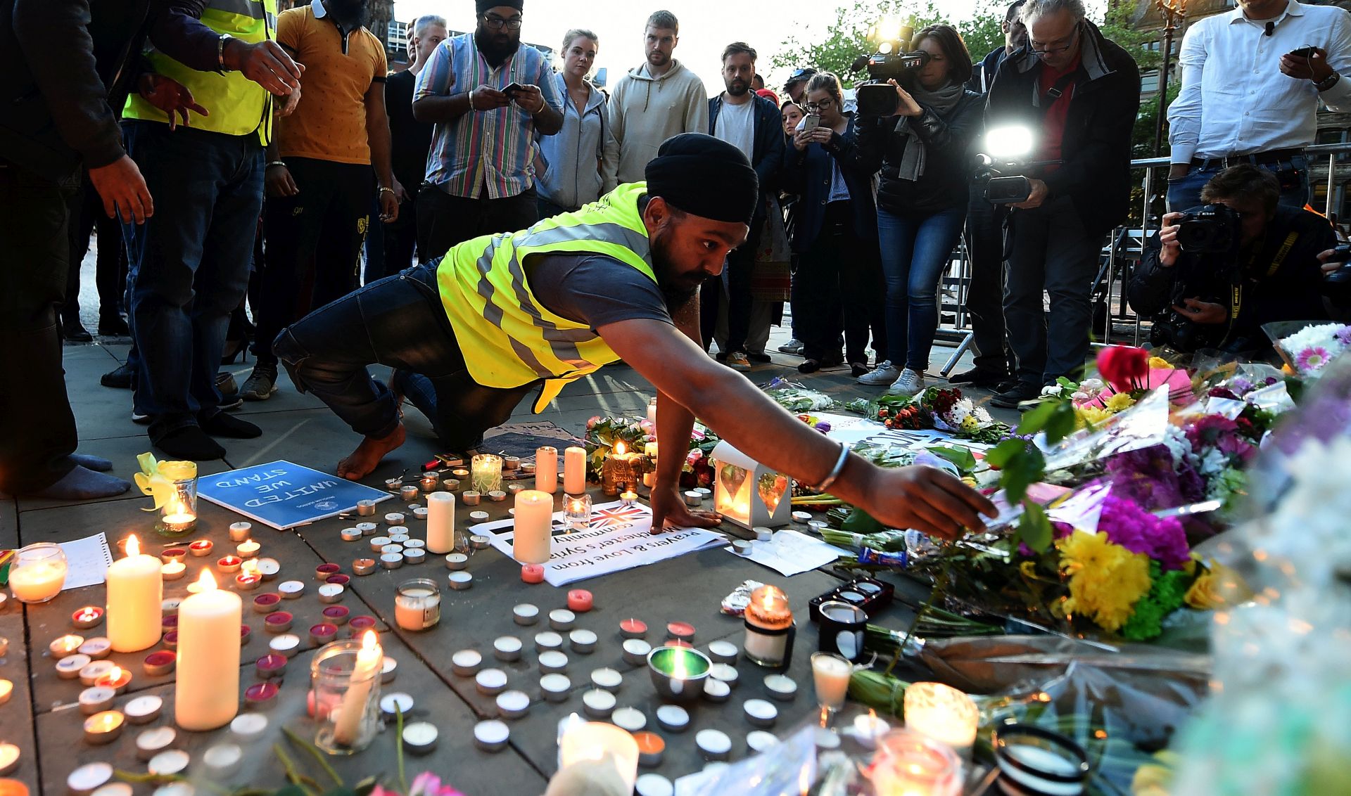 epa05984933 People lay tributes at a vigil for the people who lost their lives during the Manchester terror attack in central Manchester, Britain, 23 May 2017. Britain is on high alert following the Manchester terror attack on the Manchester Arena late 22 May, that saw 22 people lose their lives with scores of people injured.  EPA/ANDY RAIN