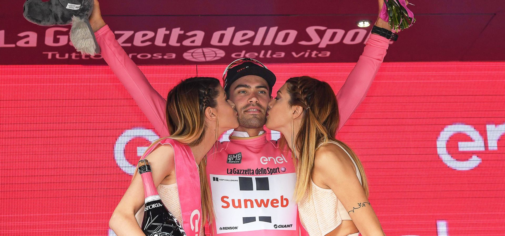 epa05986993 Dutch rider Tom Dumoulin (C) of Team Sunweb is kissed by two hostesses on the podium after retaining the overall leader's pink jersey following the 17th stage of the 100th Giro d'Italia cycling race over 219km from Tirano to Canazei, Italy, 24 May 2017.  EPA/ALESSANDRO DI MEO