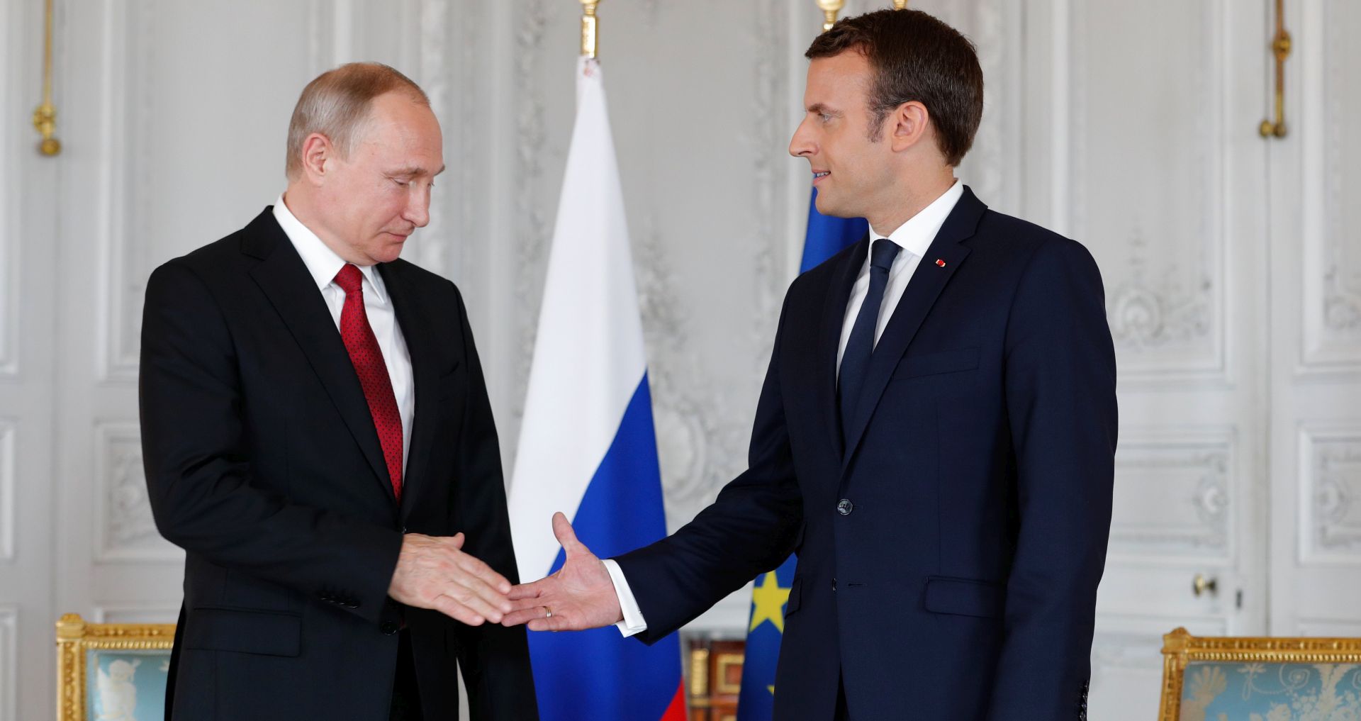 epa05997369 French President Emmanuel Macron (R) shakes hands with Russian President Vladimir Putin (L) at the Chateau de Versailles as they meet for talks before the opening of an exhibition marking 300 years of diplomatic ties between the two countyies, in Versailles, France, 29 May 2017. Discussions are expected to include the situation in Syria and Russia's veto position at the UN security council.  EPA/PHILIPPE WOJAZER / POOL MAXPPP OUT