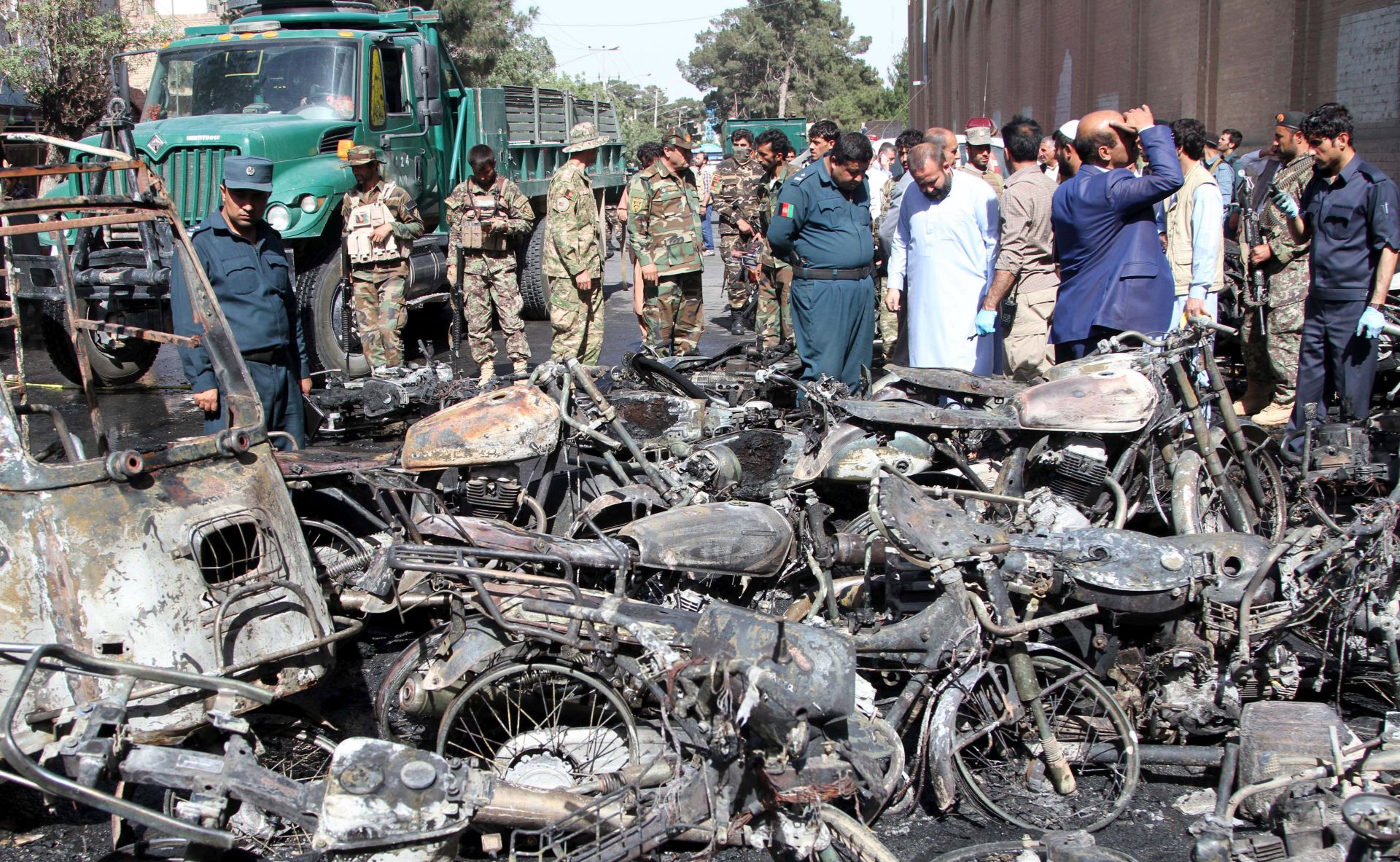 epa06013153 Afghan security officials inspect the scene of a bomb blast outside the Great Mosque in Herat, Afghanistan, 06 June 2017. At least eight people were killed and 15 injured when a bomb planted in a motorbike exploded outside the Great Mosque of Herat.  EPA/JALIL REZAYEE