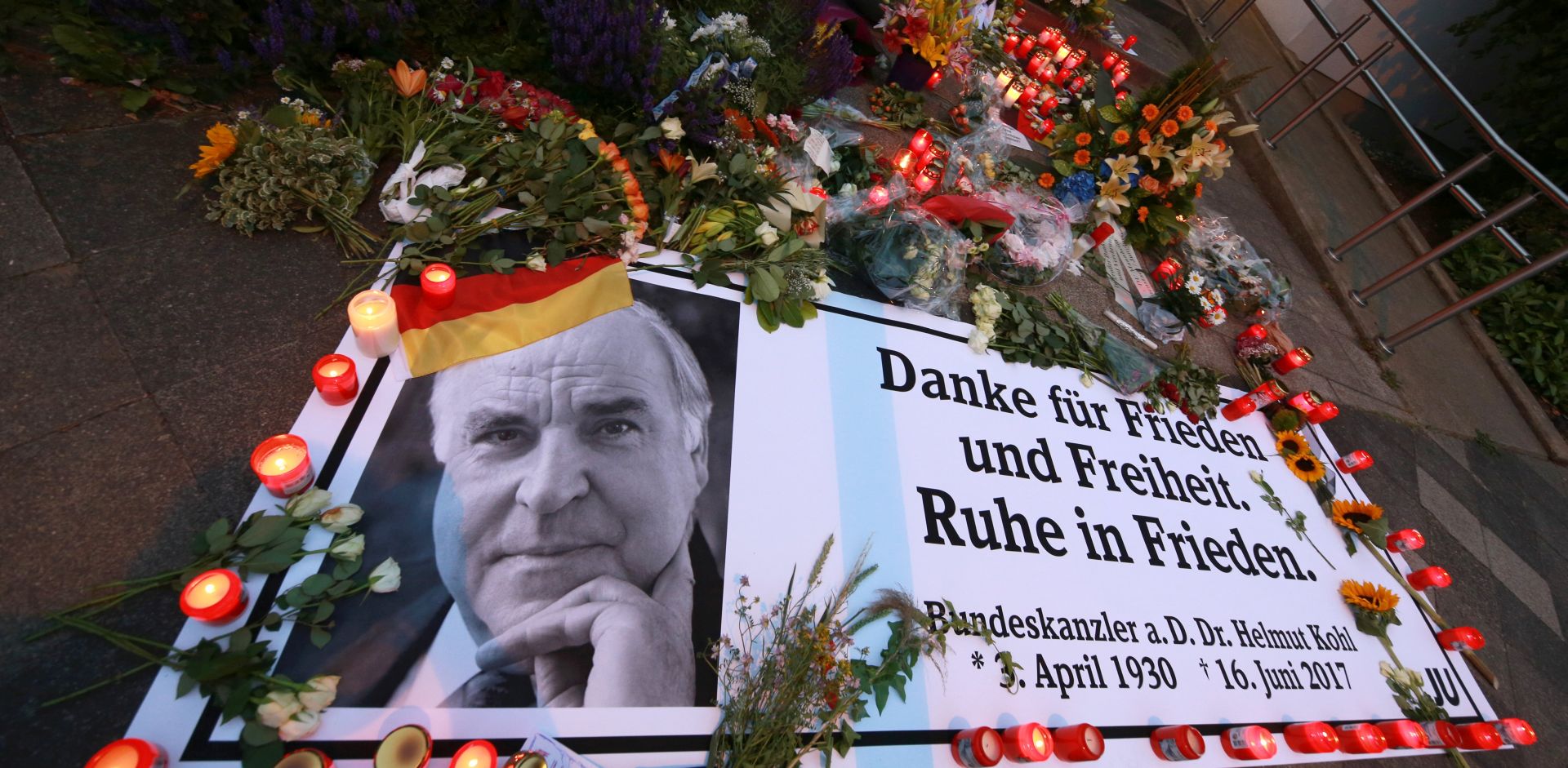 epa06034307 A banner reading 'Thank you for peace and freedom. Rest in peace.' lays next to lit candles and flowers in front of the house of former German Chancellor Helmut Kohl in Oggersheim, Ludwigshafen, Germany, 17 June 2017. Helmut Kohl has died at the age of 87 in his home in Ludwigshafen on 16 June 2017.  EPA/MICHAEL DEINES